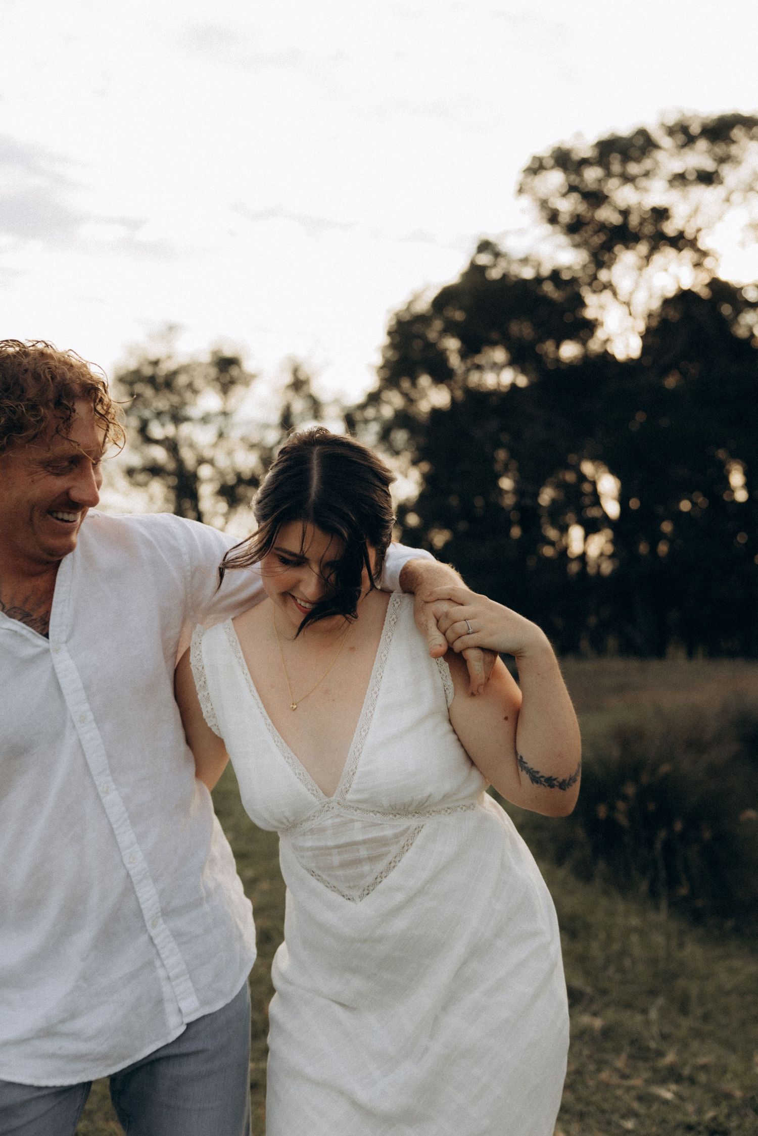 Intimate moment between couple laughing together in natural outdoor setting.