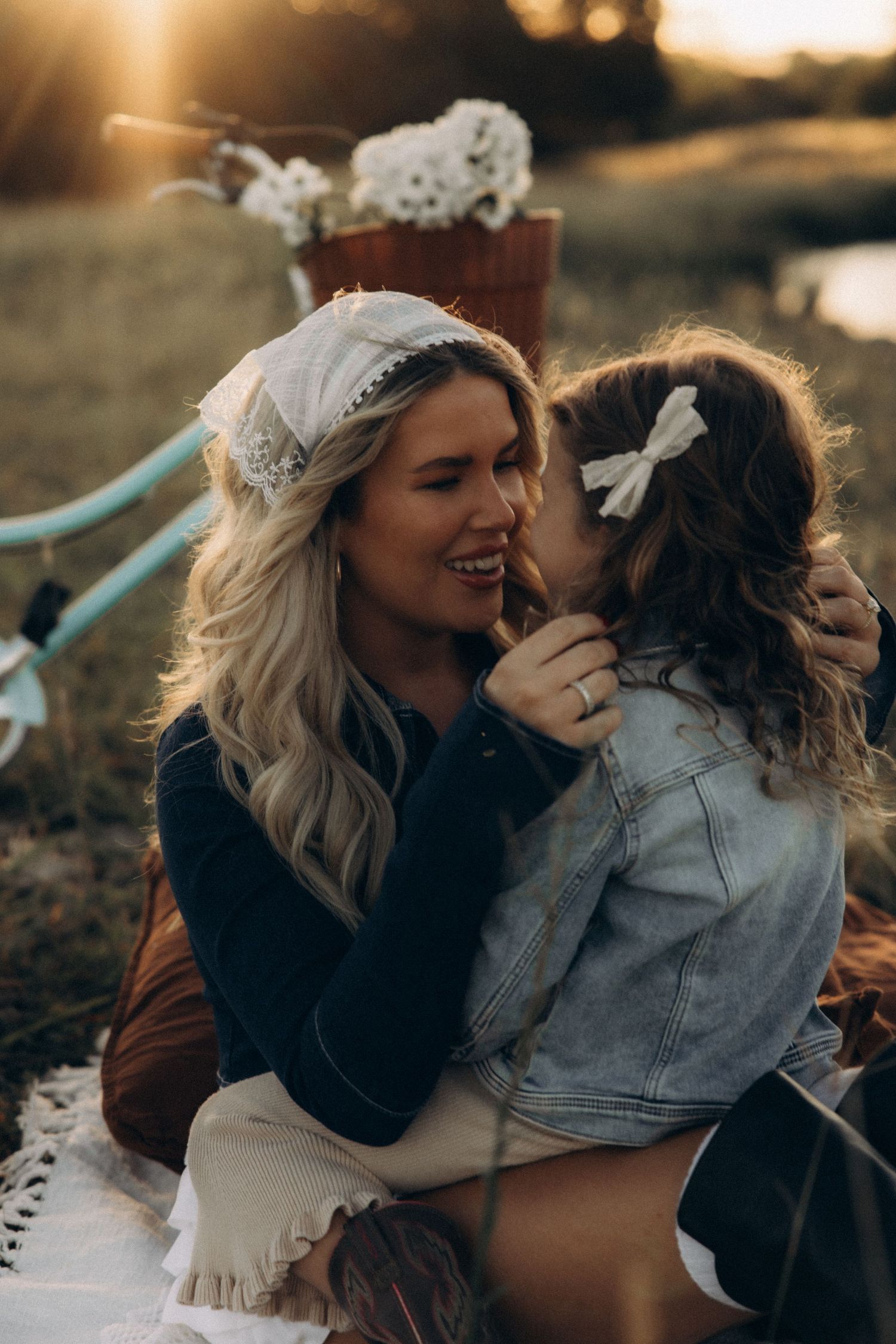 Two people sharing laughter and embracing during sunset in a field.
