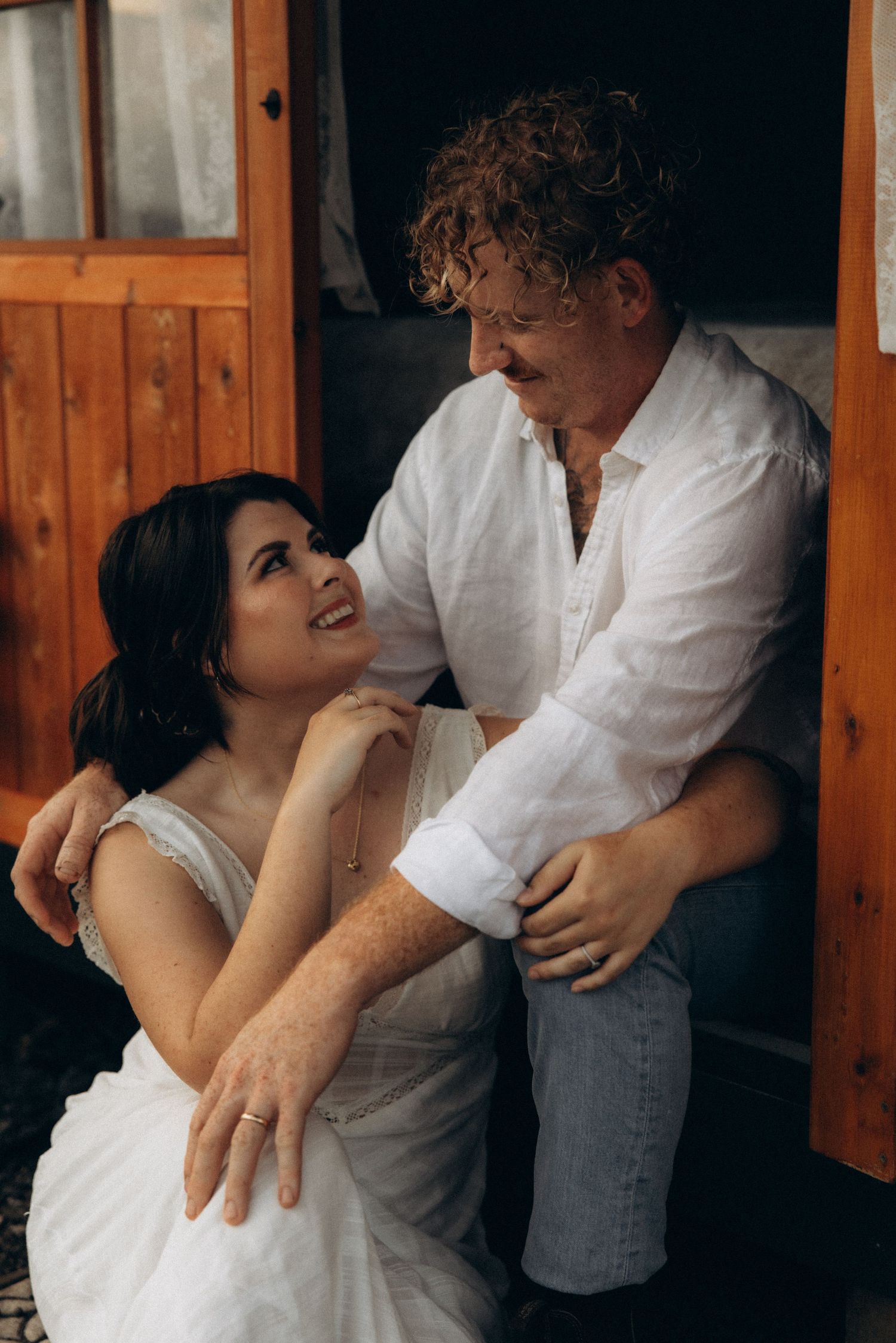 A tender moment captured between a couple on a rustic wooden porch.