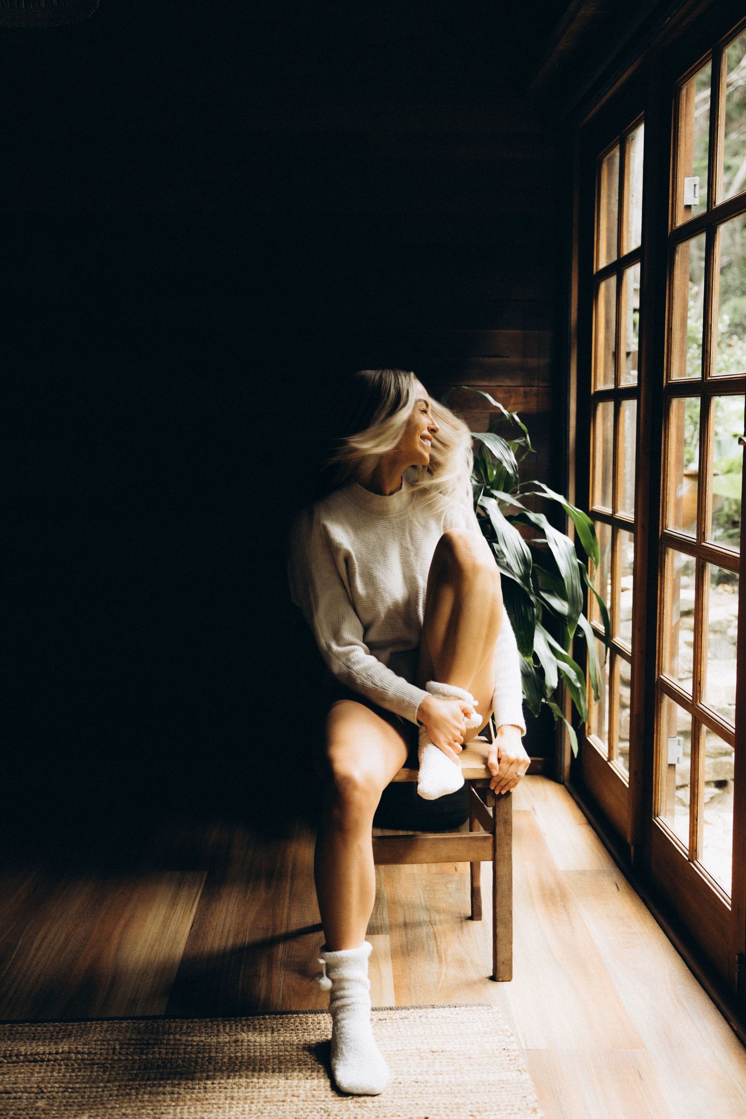 Moody indoor portrait sequence near sunlit windows with dramatic shadows.