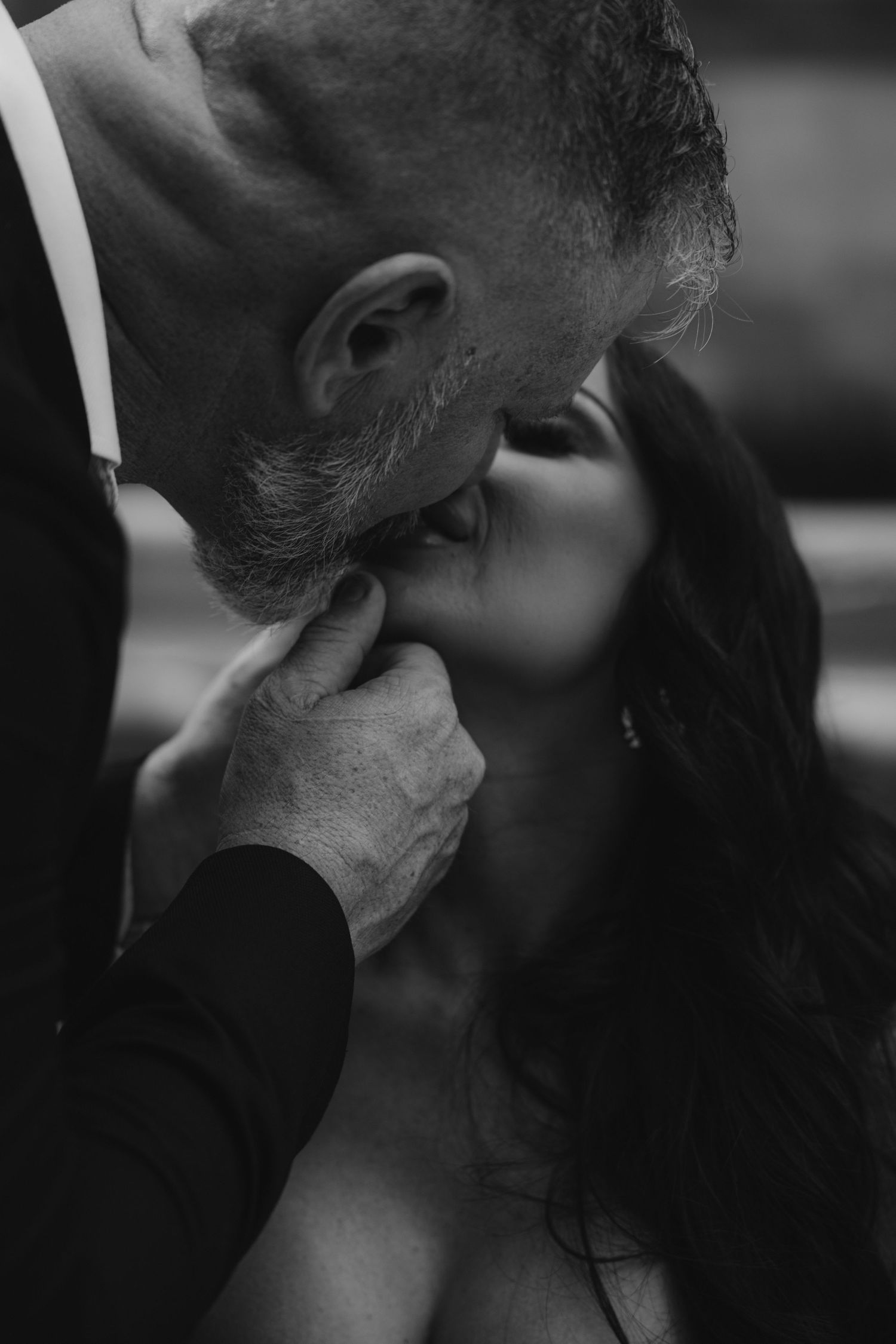 An intimate black and white close-up of a tender wedding moment.