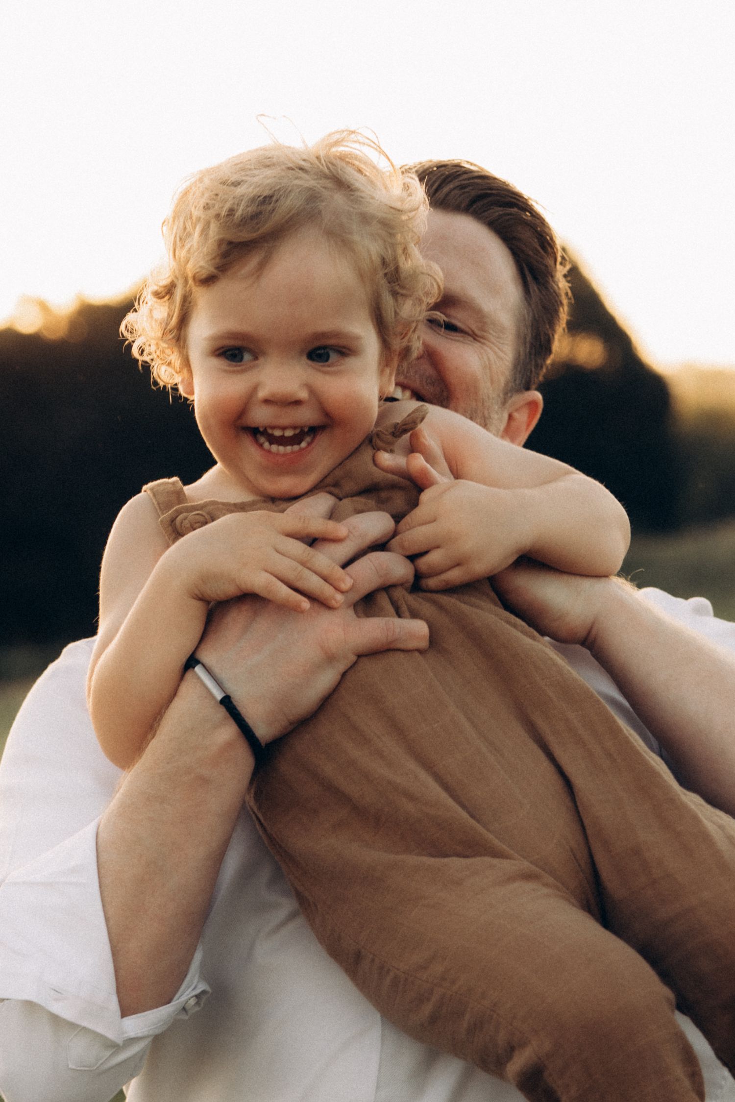 Joyful embrace captured in warm evening light outdoors.
