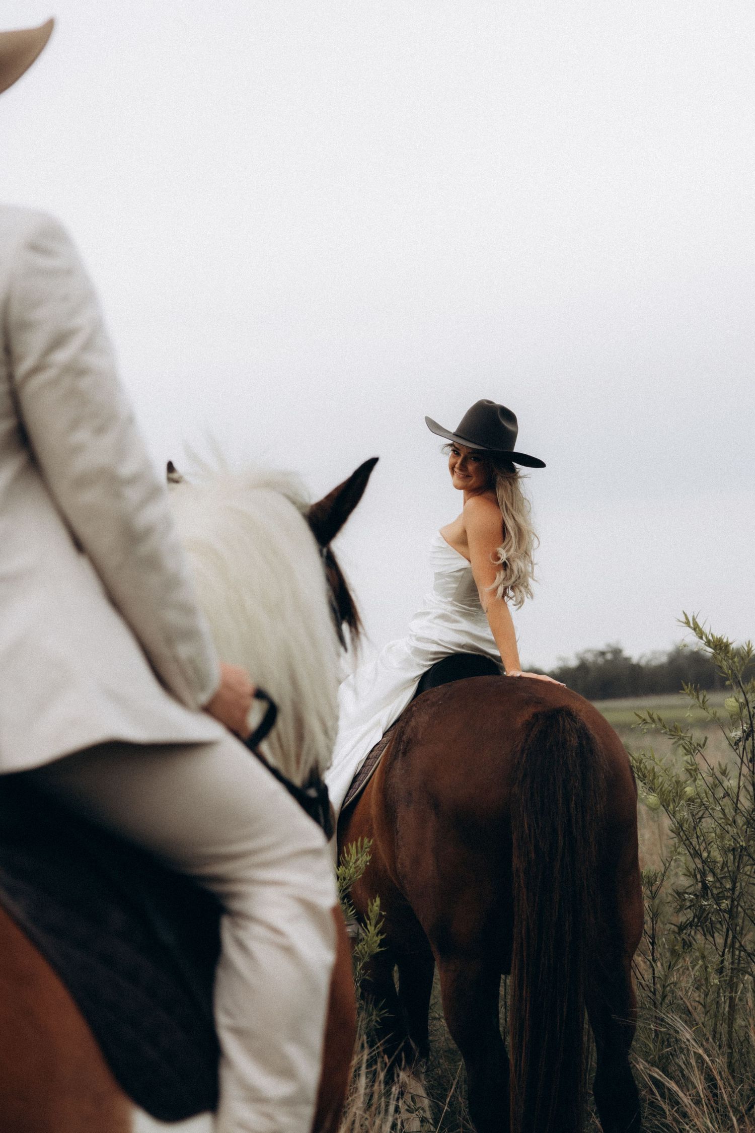 Side view of riders mounted on horses in a natural setting.