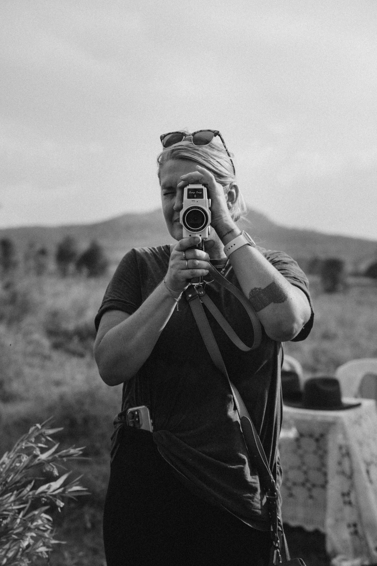 Photographer with camera taking pictures in a rural landscape setting.