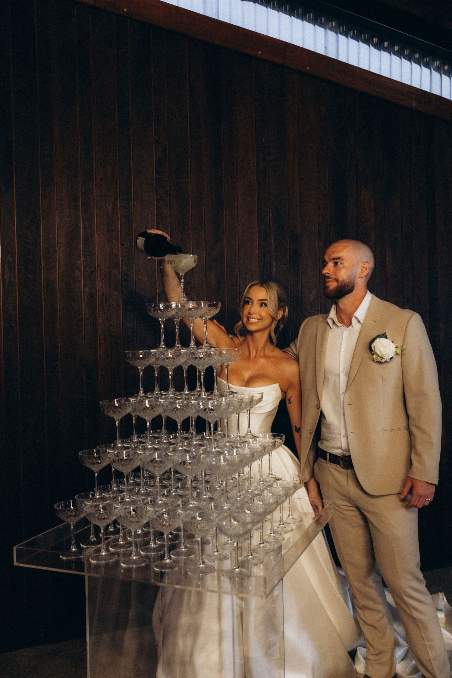 A champagne tower display at a wedding reception with elegant glassware.