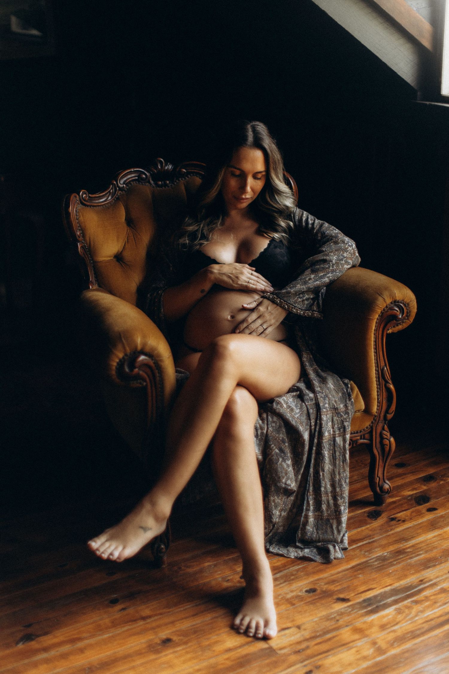 A series of moody photographs showing bare feet on a wooden floor next to an antique chair in dramatic lighting.