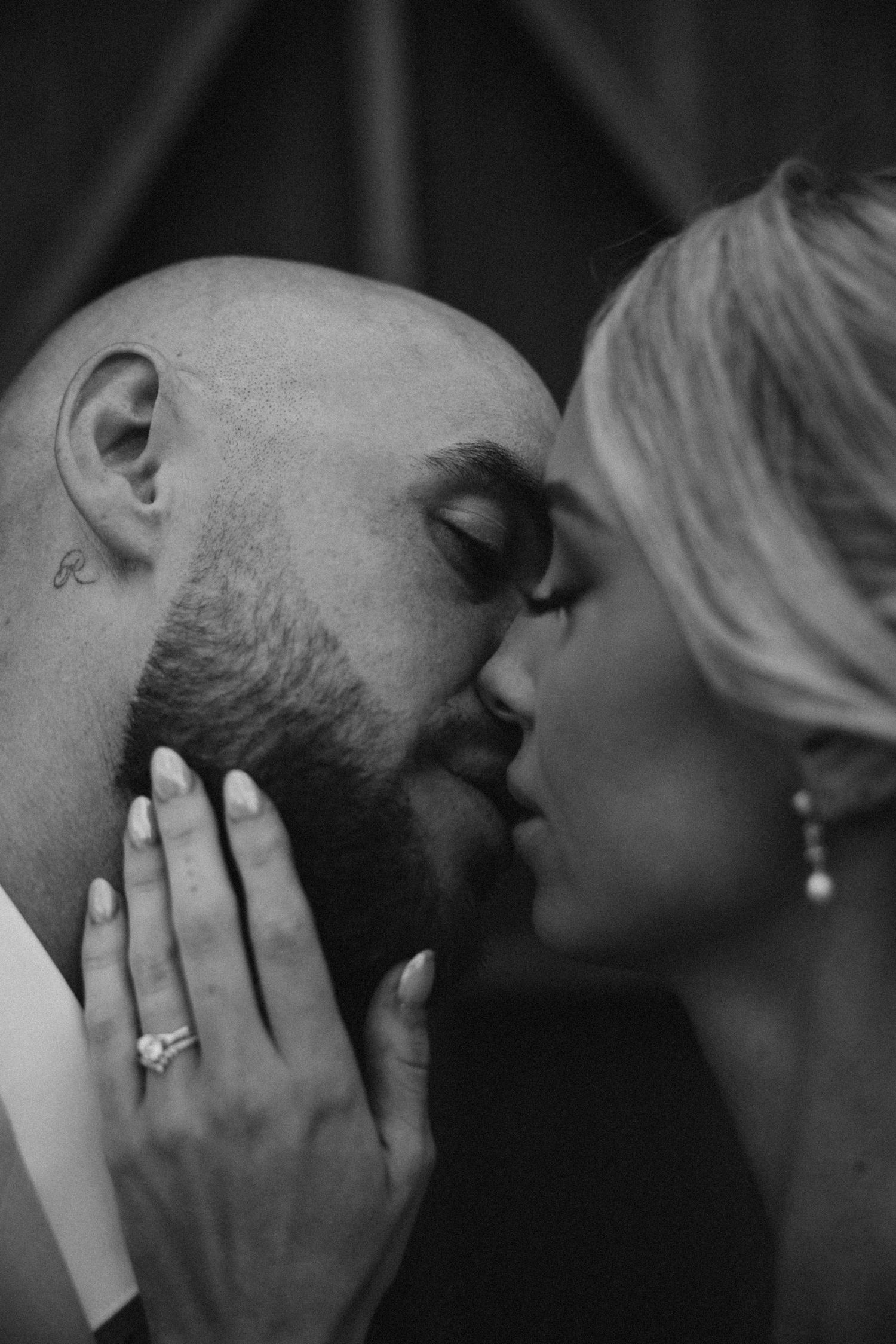 Intimate black and white portrait of a tender wedding kiss.