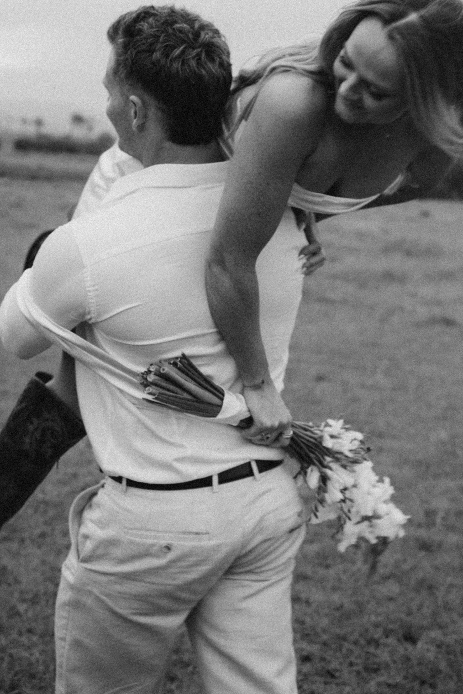 Close-up of a couple holding flowers during their rustic outdoor wedding.