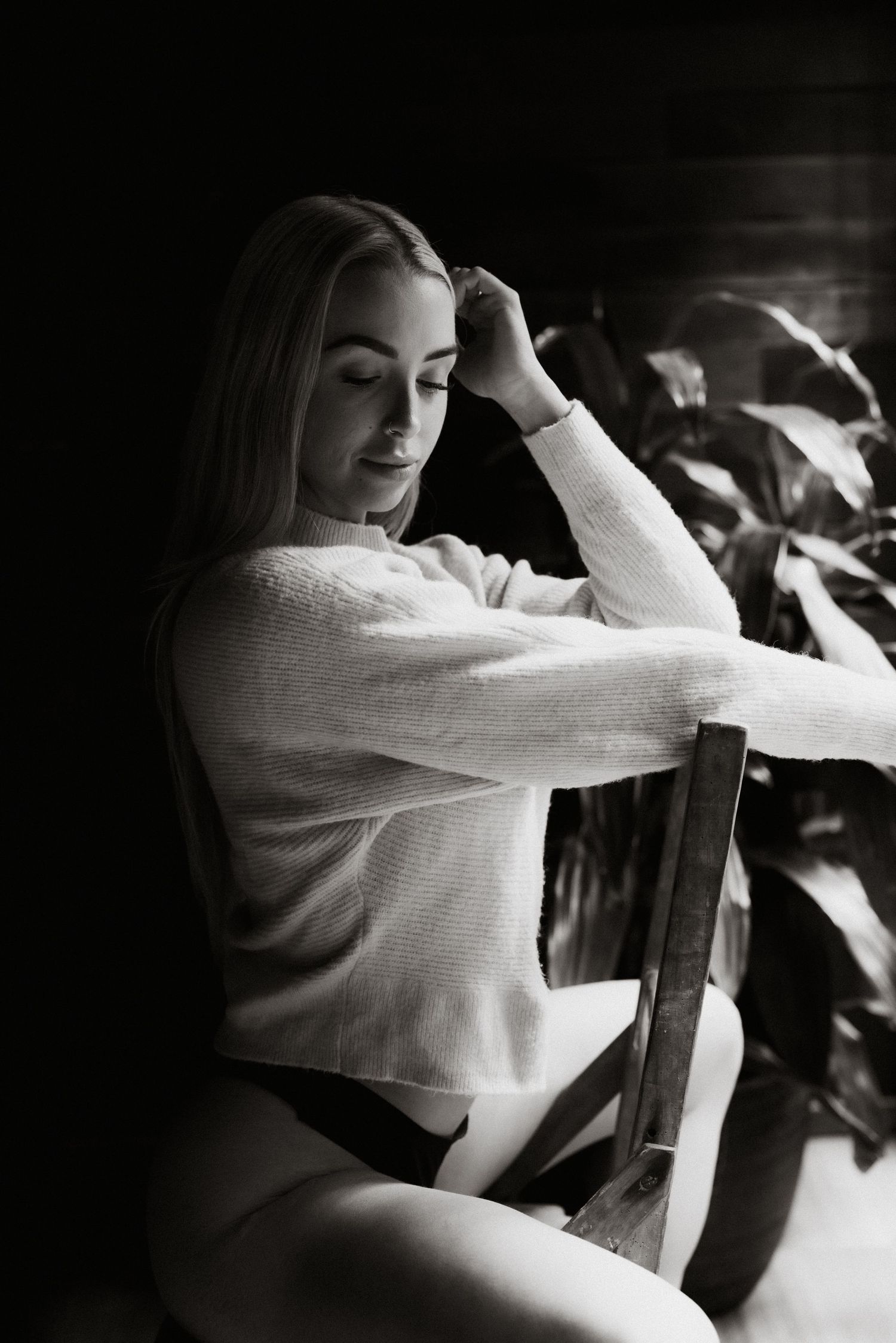 Artistic black and white photo sequence showing movement in a white sweater against dark background.