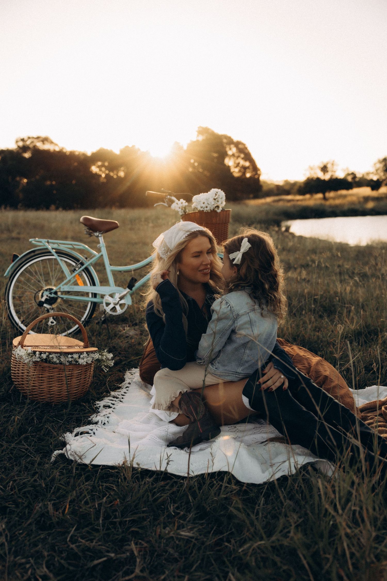 A couple shares intimate moments during their sunset picnic with a vintage bicycle nearby.