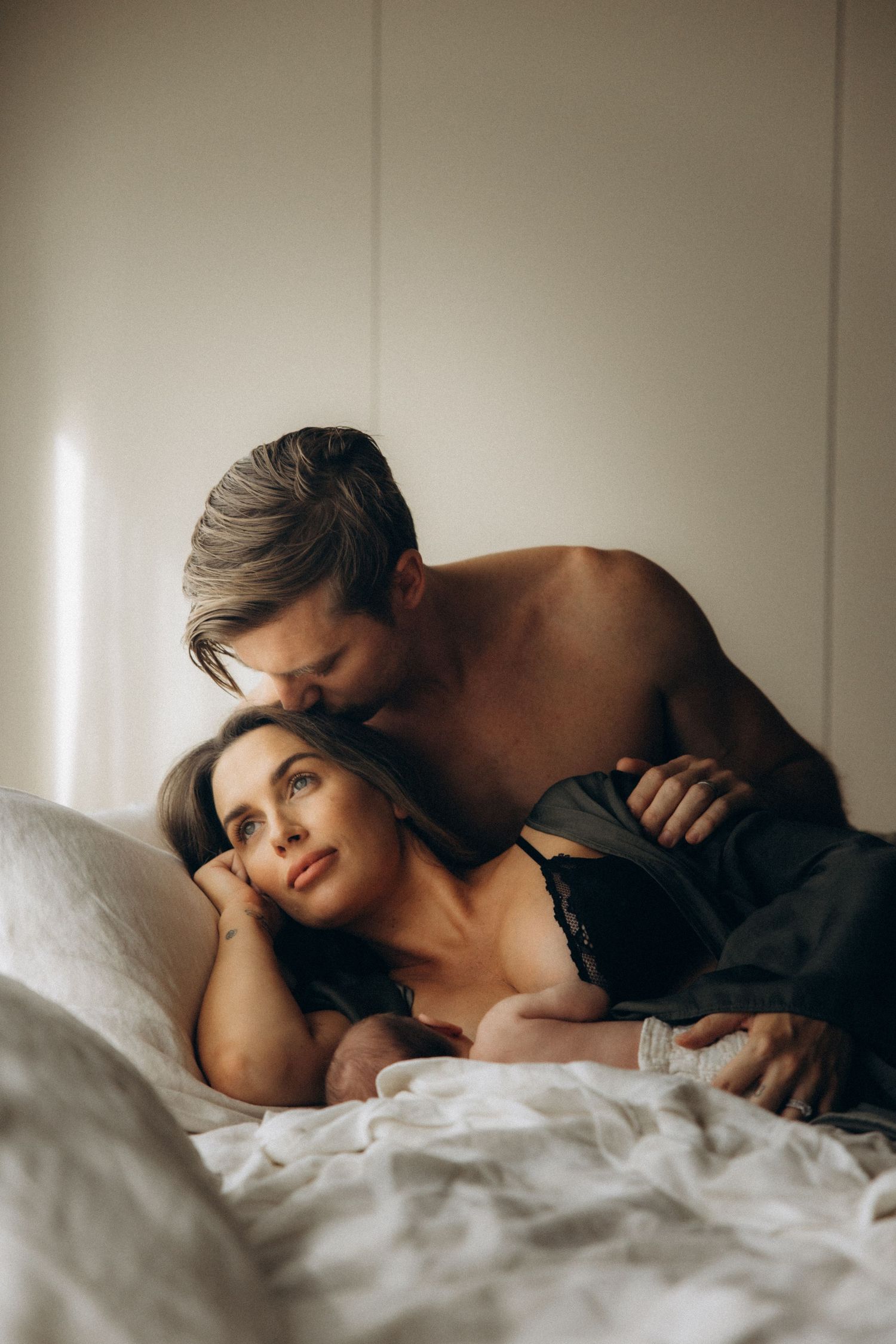 Intimate black and white bedroom portrait with soft natural window lighting.
