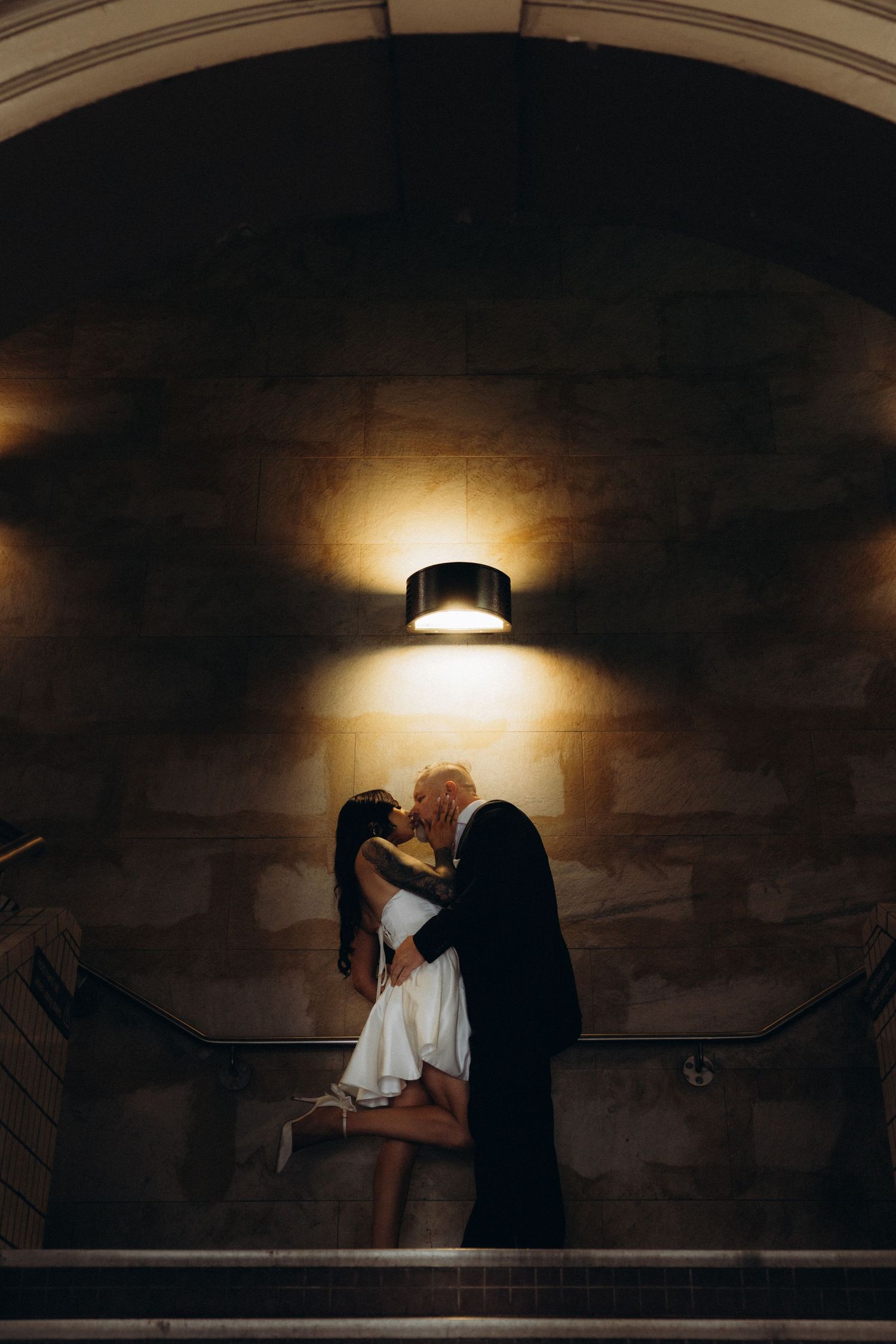 Moody silhouettes in dimly lit tunnel with dramatic lighting creating atmospheric scene.