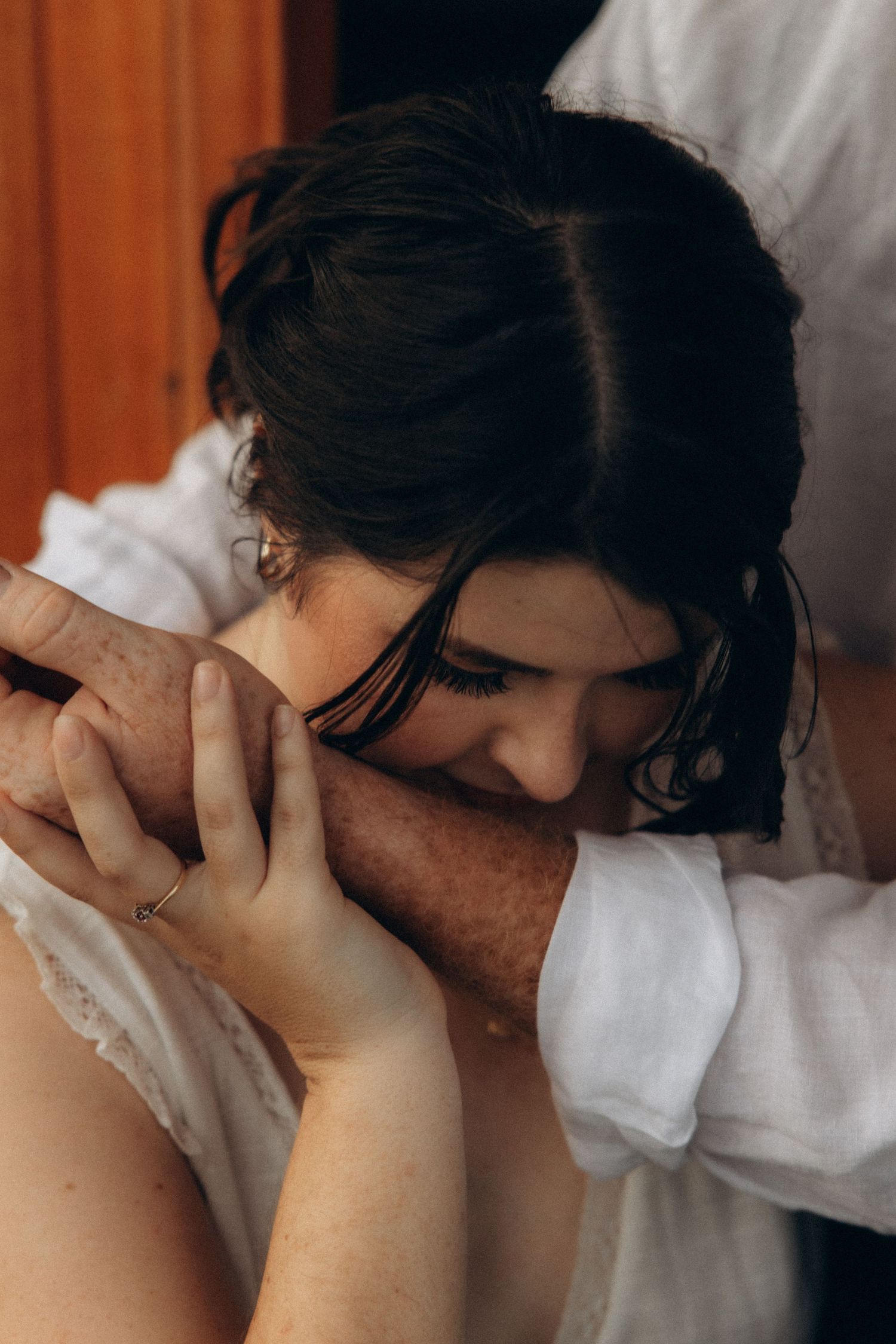 A close-up intimate moment between two people in white and casual attire.