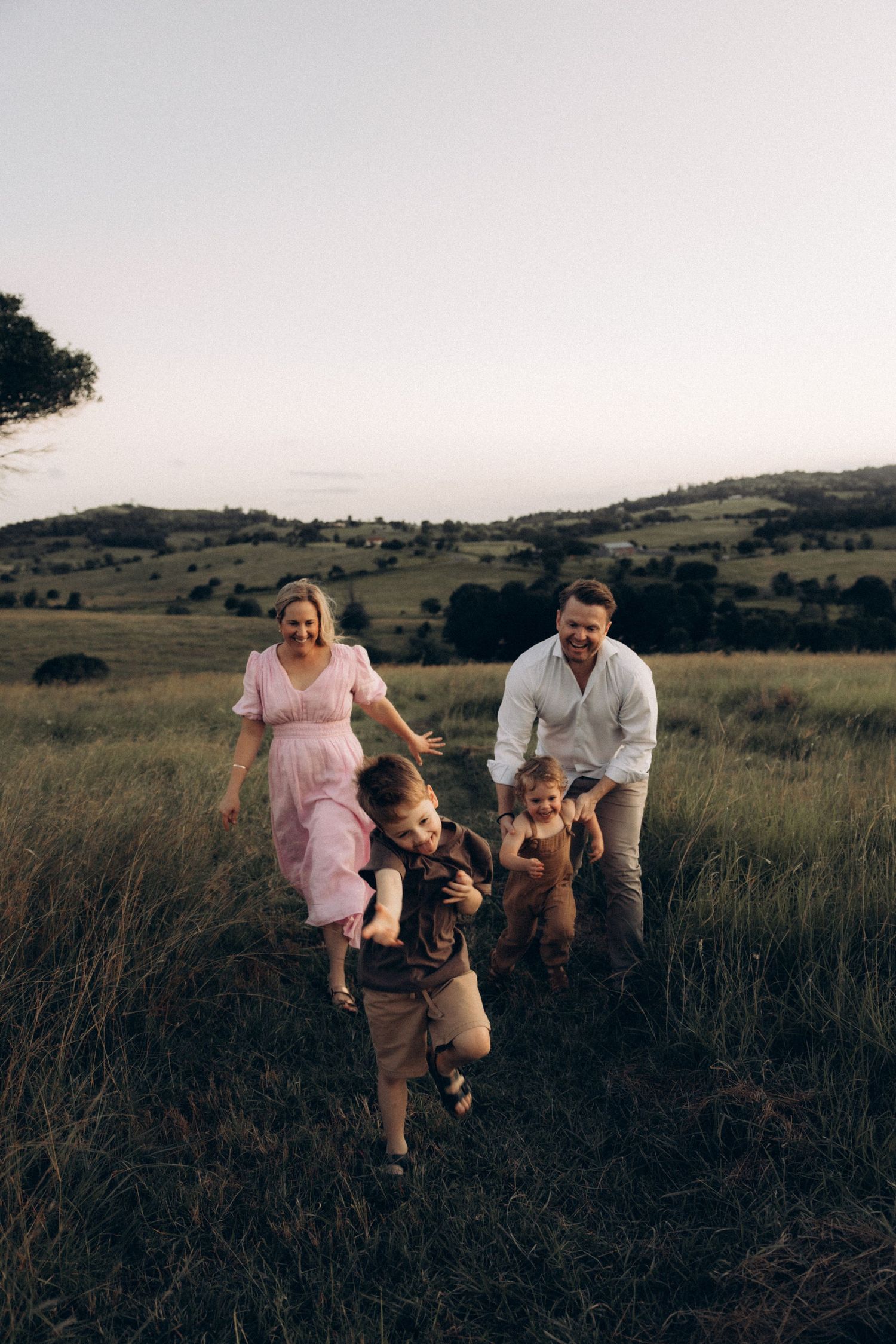 A family enjoys quality time together in a scenic field during sunset.