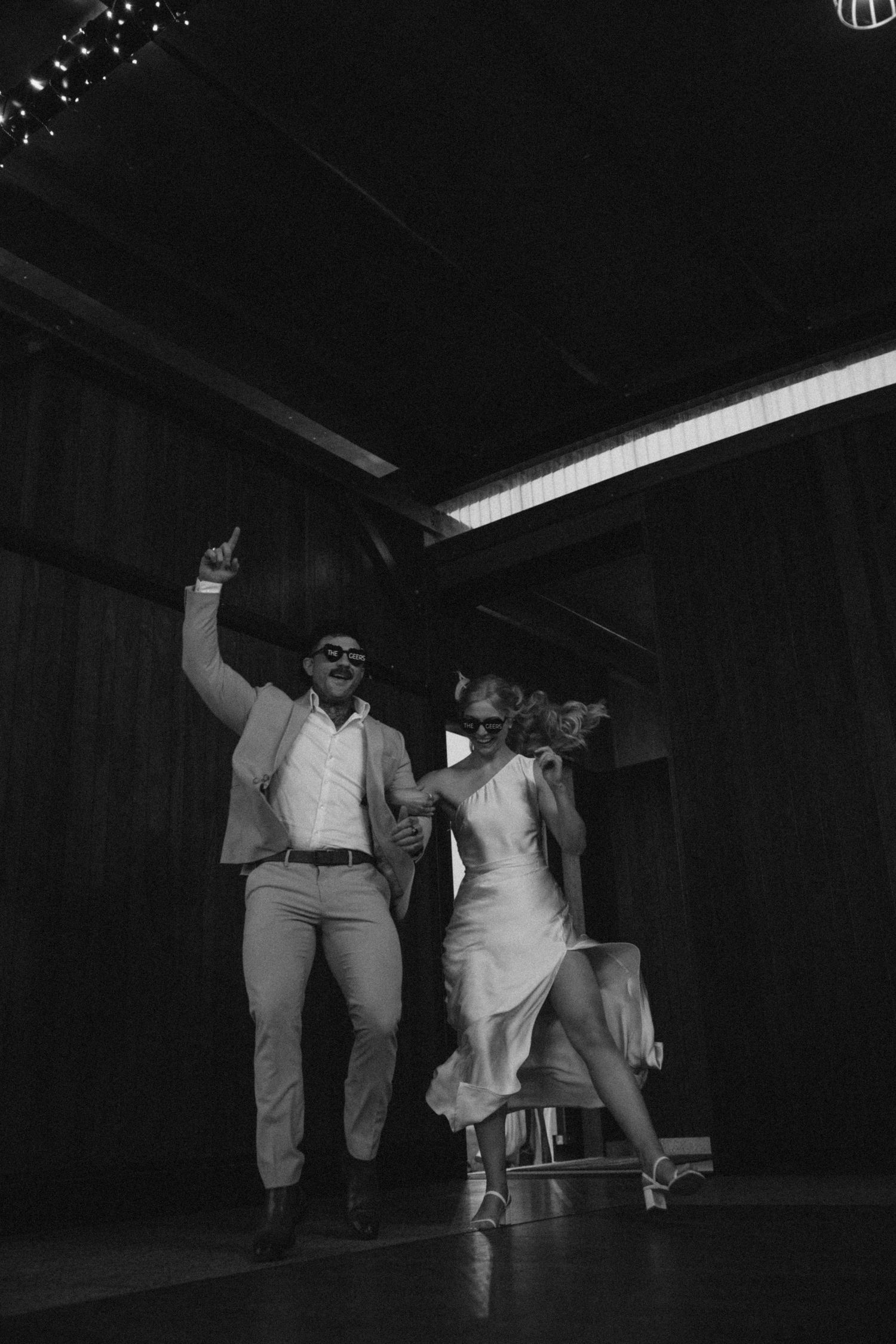 Dynamic black and white shot of a couple dancing at their wedding reception.