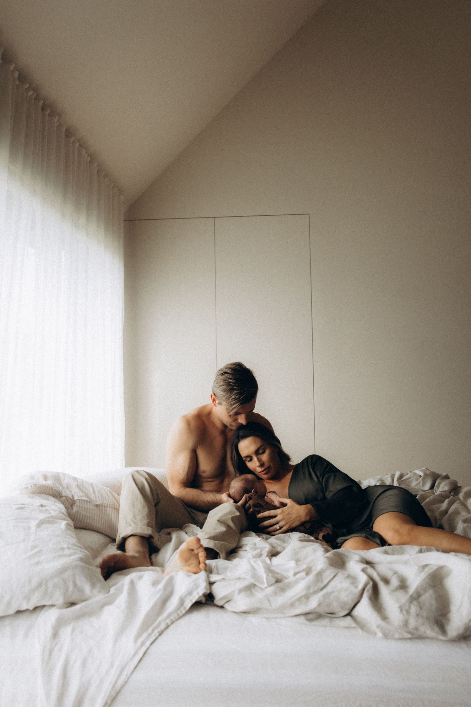 Tender morning moment captured in minimalist bedroom with natural light.