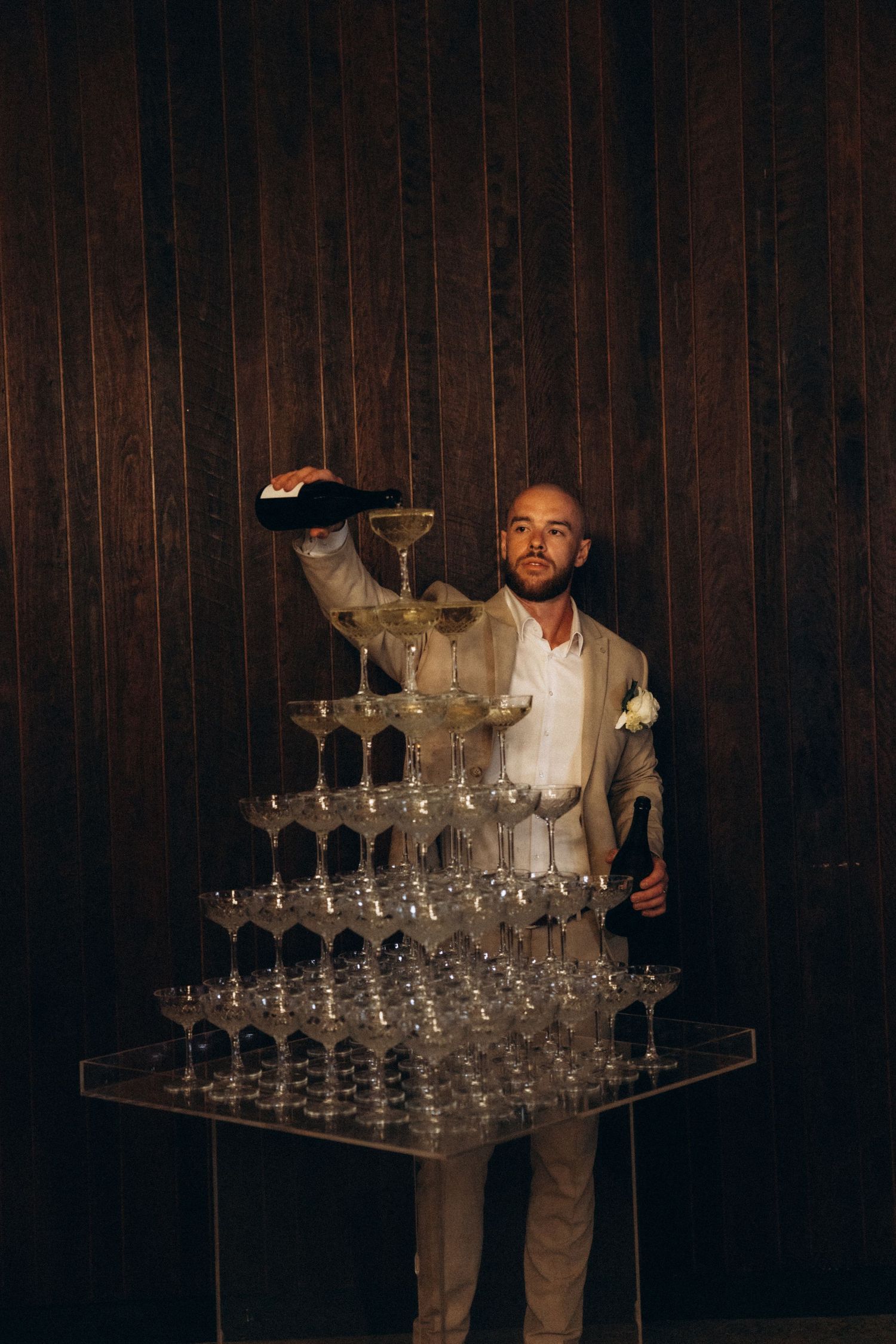 A dramatic shot of a champagne glass tower display at an evening reception.
