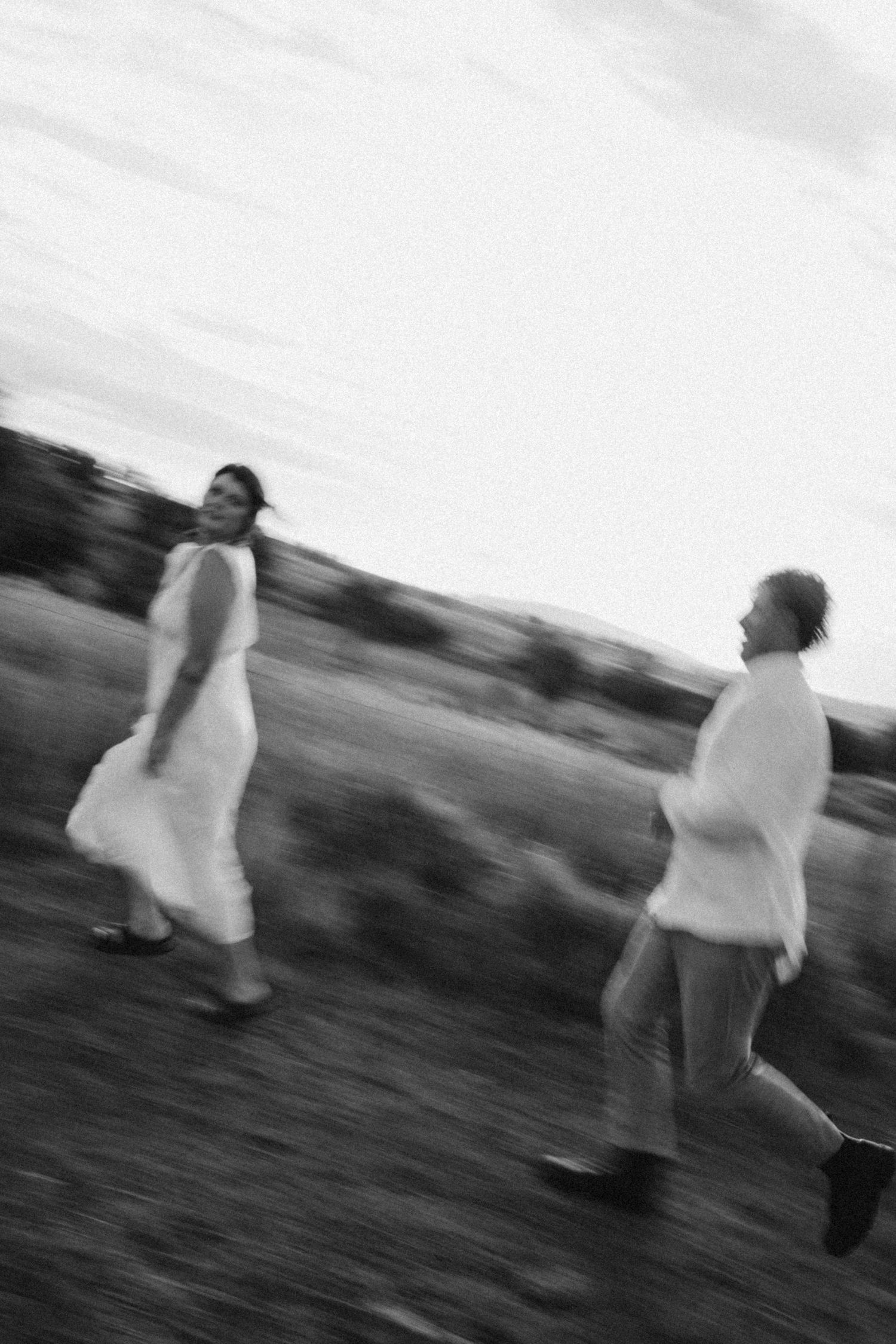 Motion-blurred photograph of two people dancing in white clothing.
