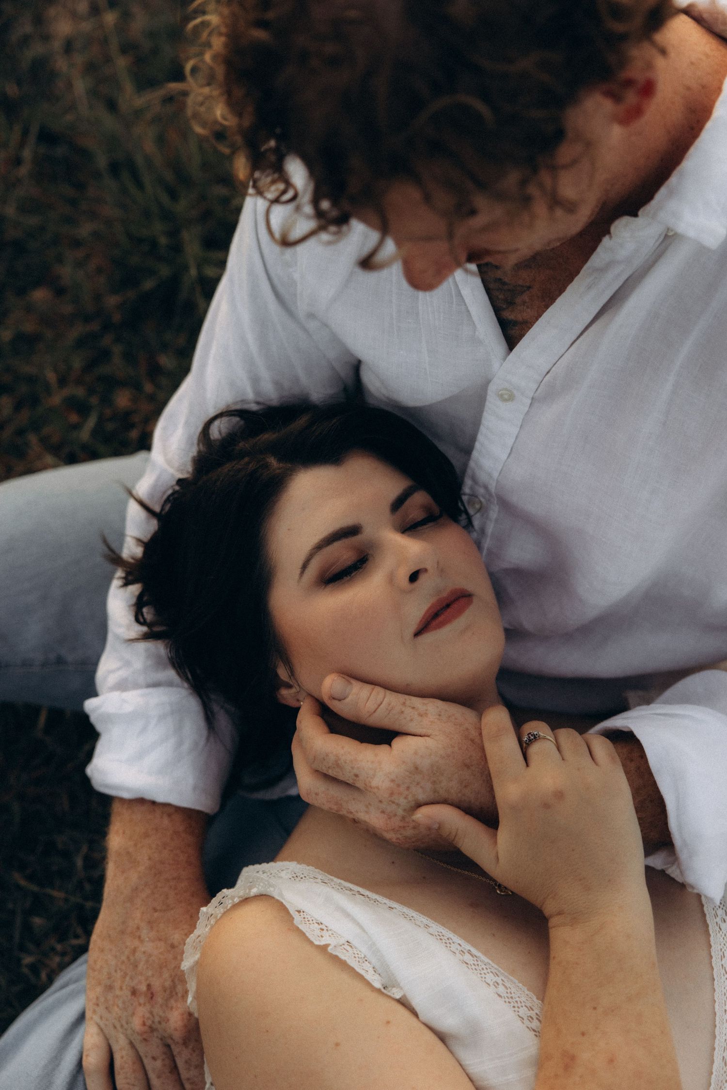 Intimate black and white portrait of a couple sharing a tender moment outdoors.