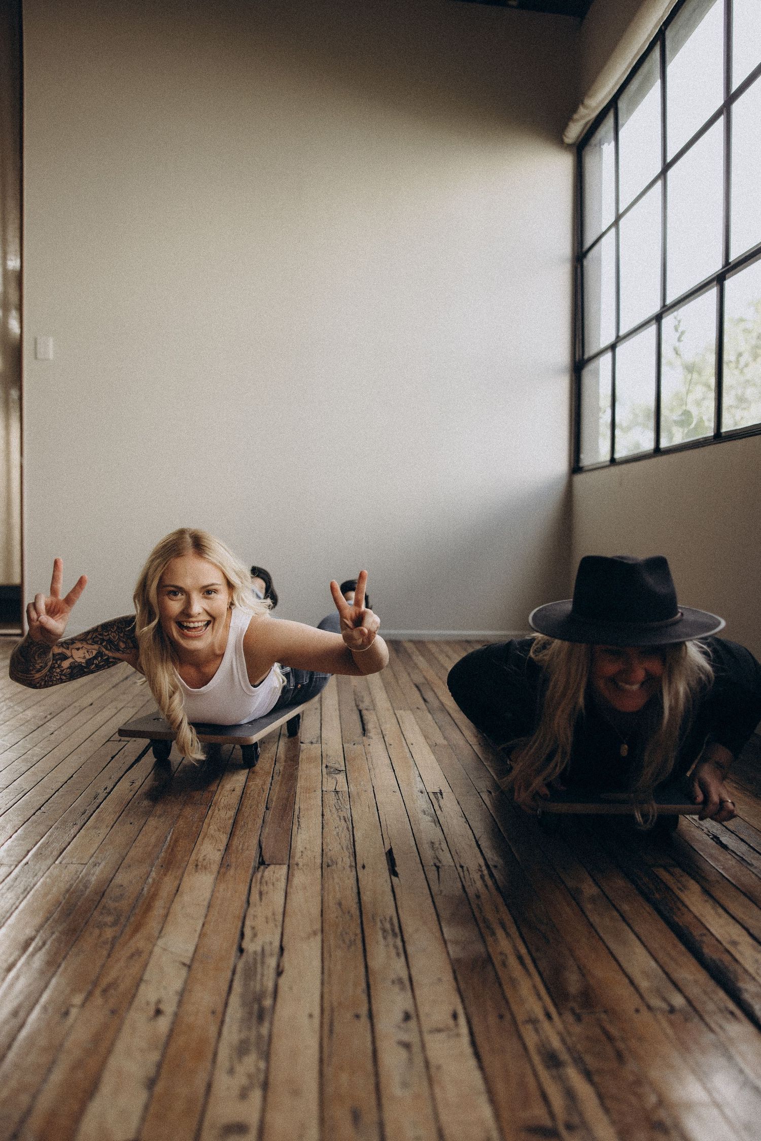 Playful photo sequence of friends lying on wooden floor in studio setting.