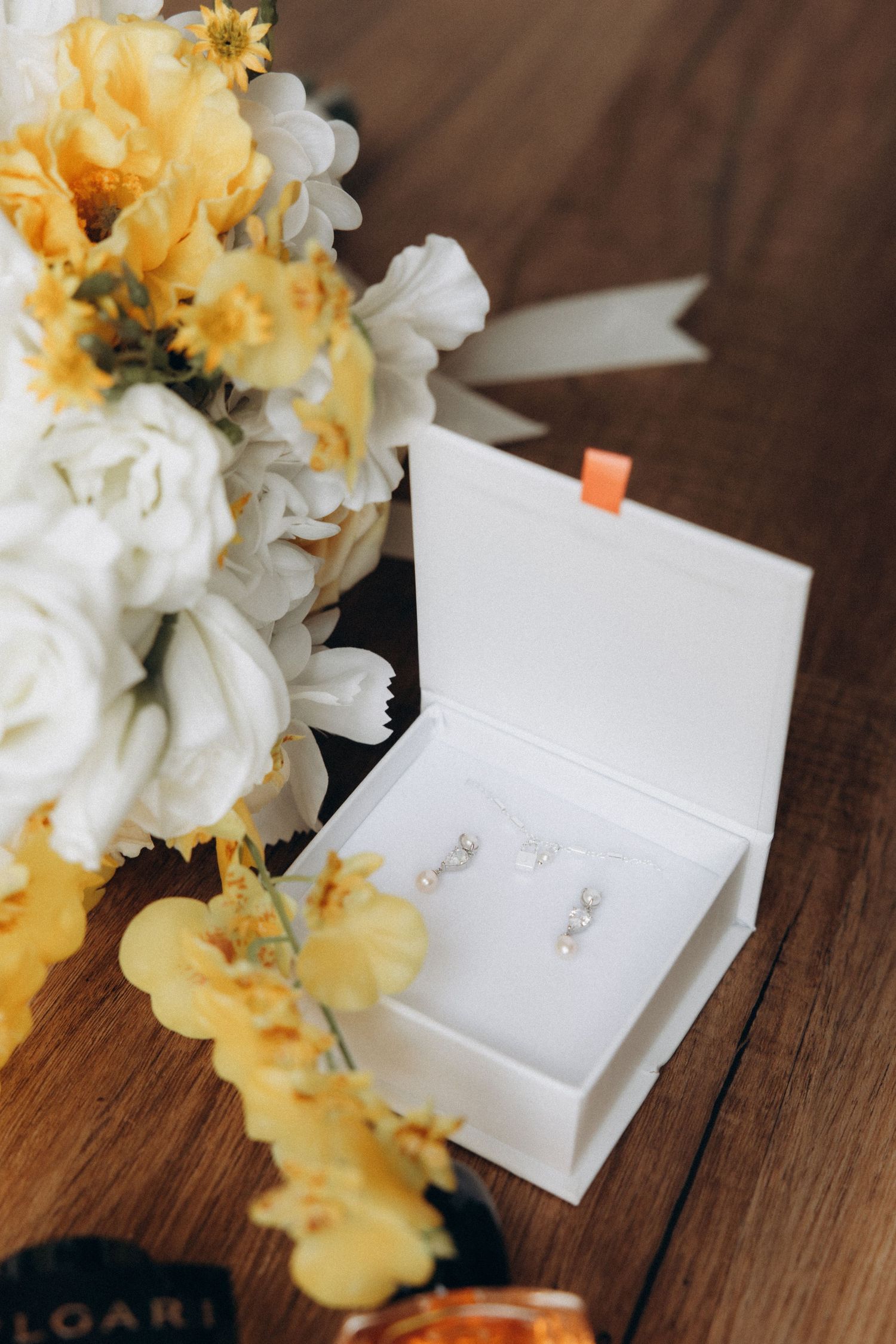 Small white cards nestled among yellow and white flowers on a wooden table.