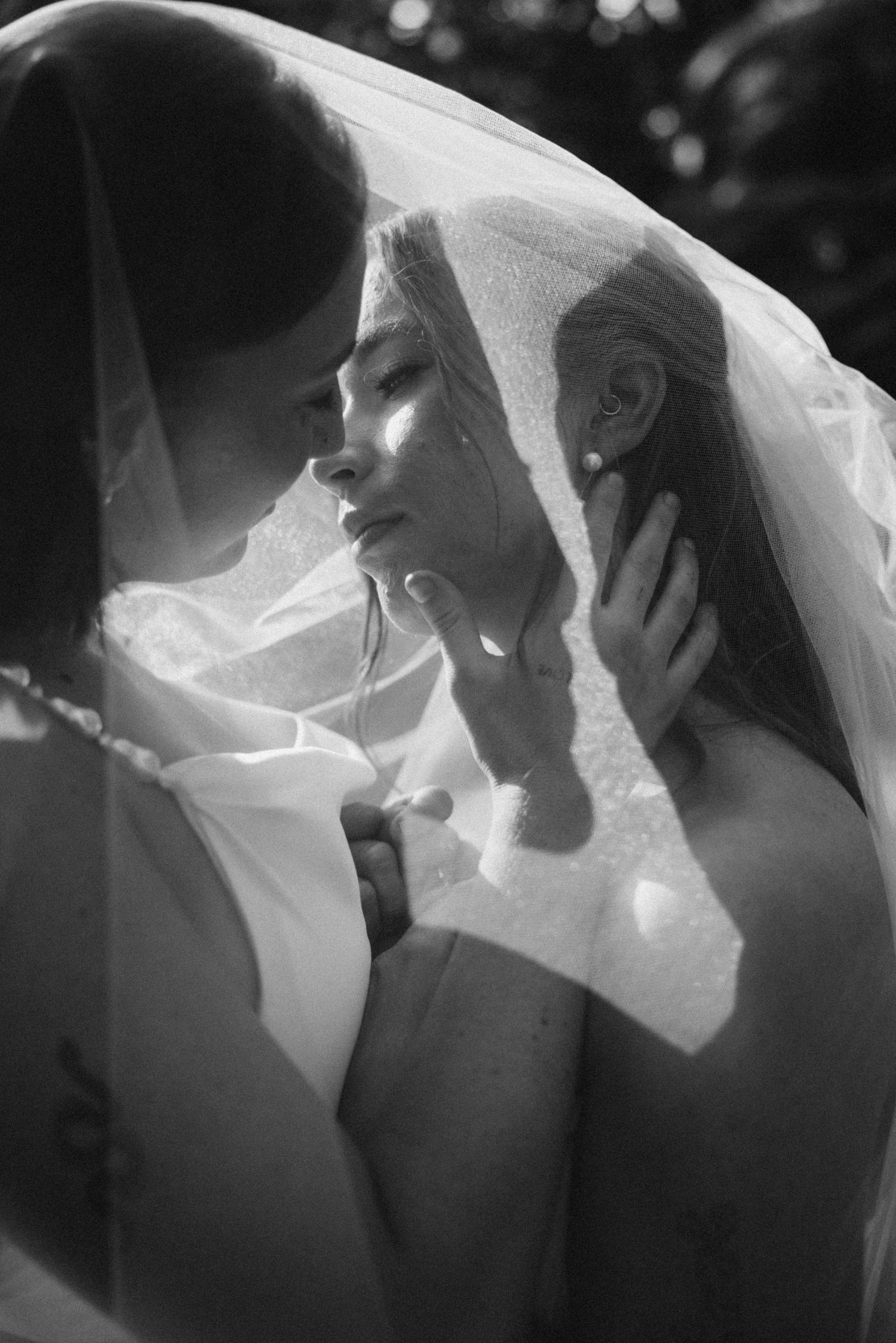 Romantic black and white sequence of a couple in wedding attire sharing intimate moments under a veil.