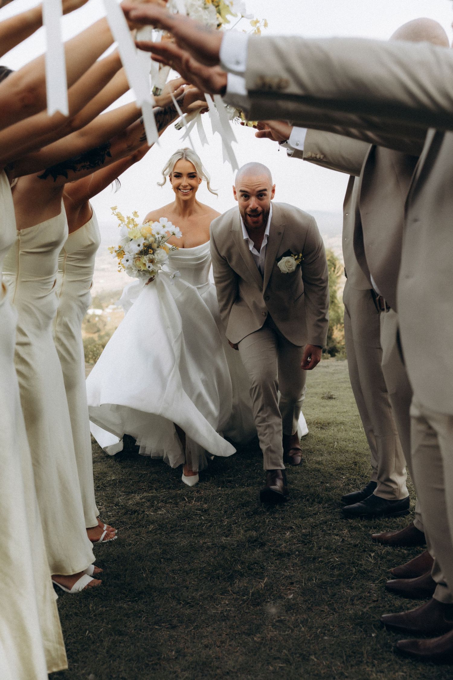 Wedding party forms an archway for the newlyweds to walk through after the ceremony.