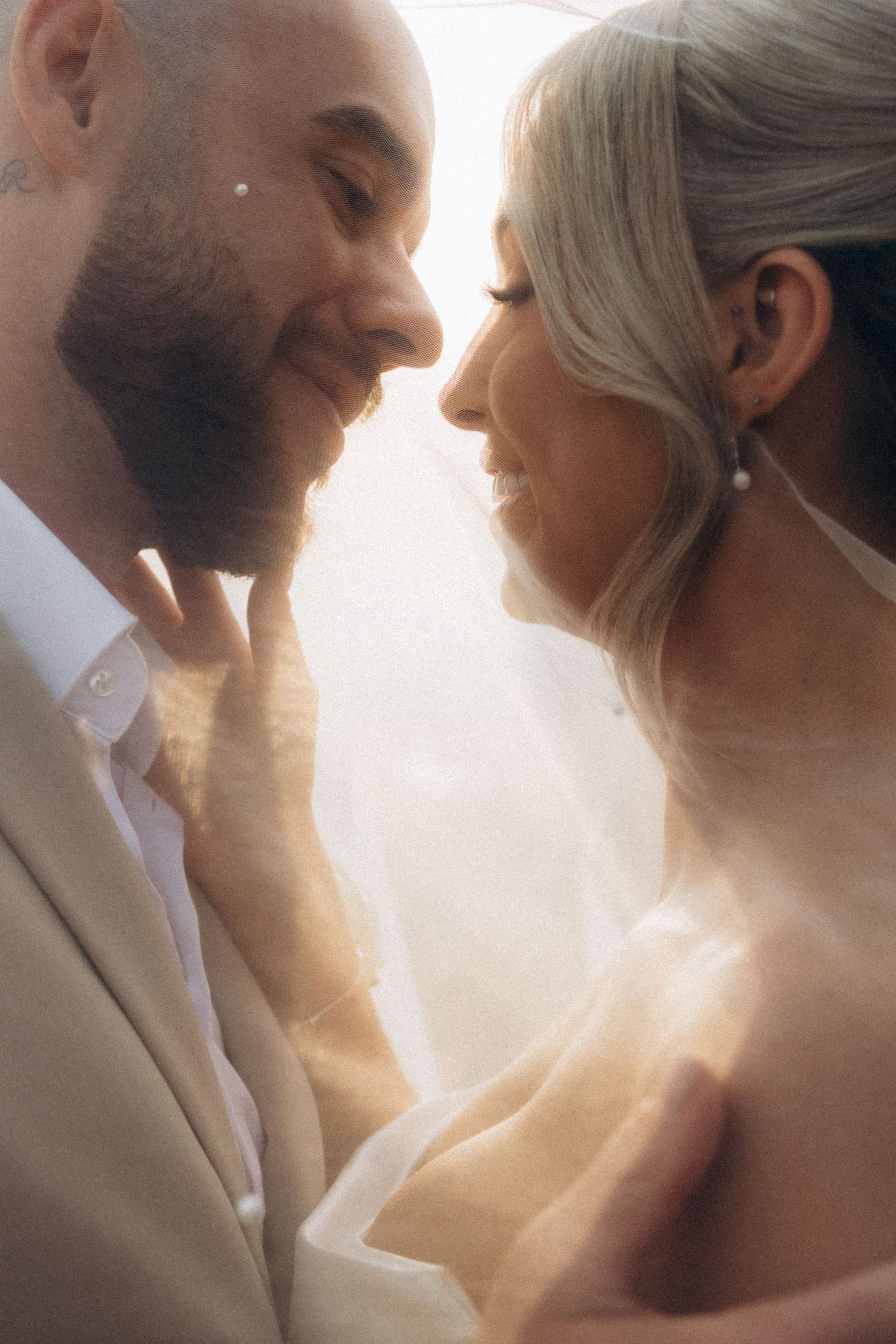 Tender moment between newlyweds captured in dreamy golden light.