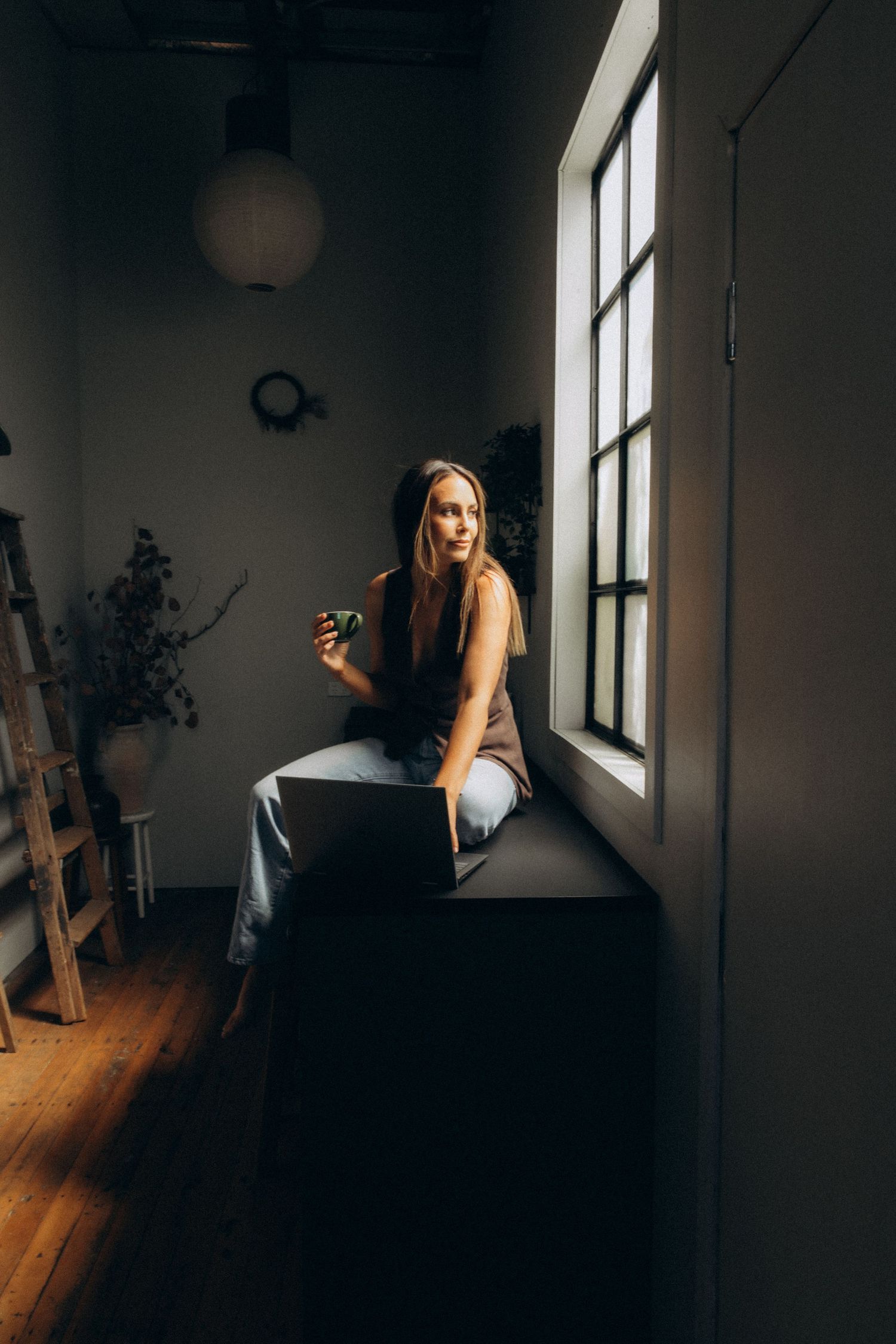 Moody interior scene with sunlight streaming through windows onto wooden floor.