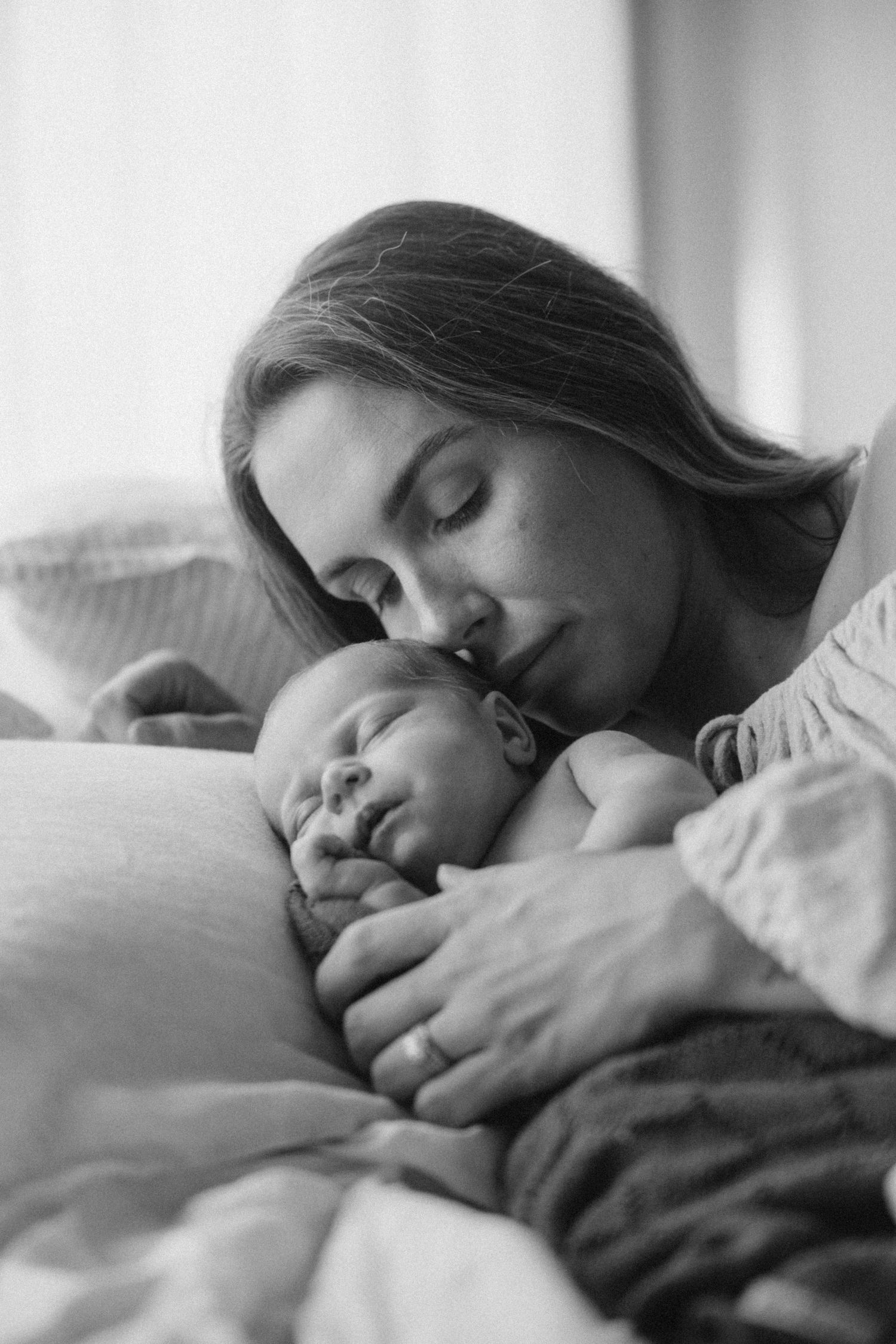 A series of intimate black and white photographs showing peaceful moments of rest on white bedding.