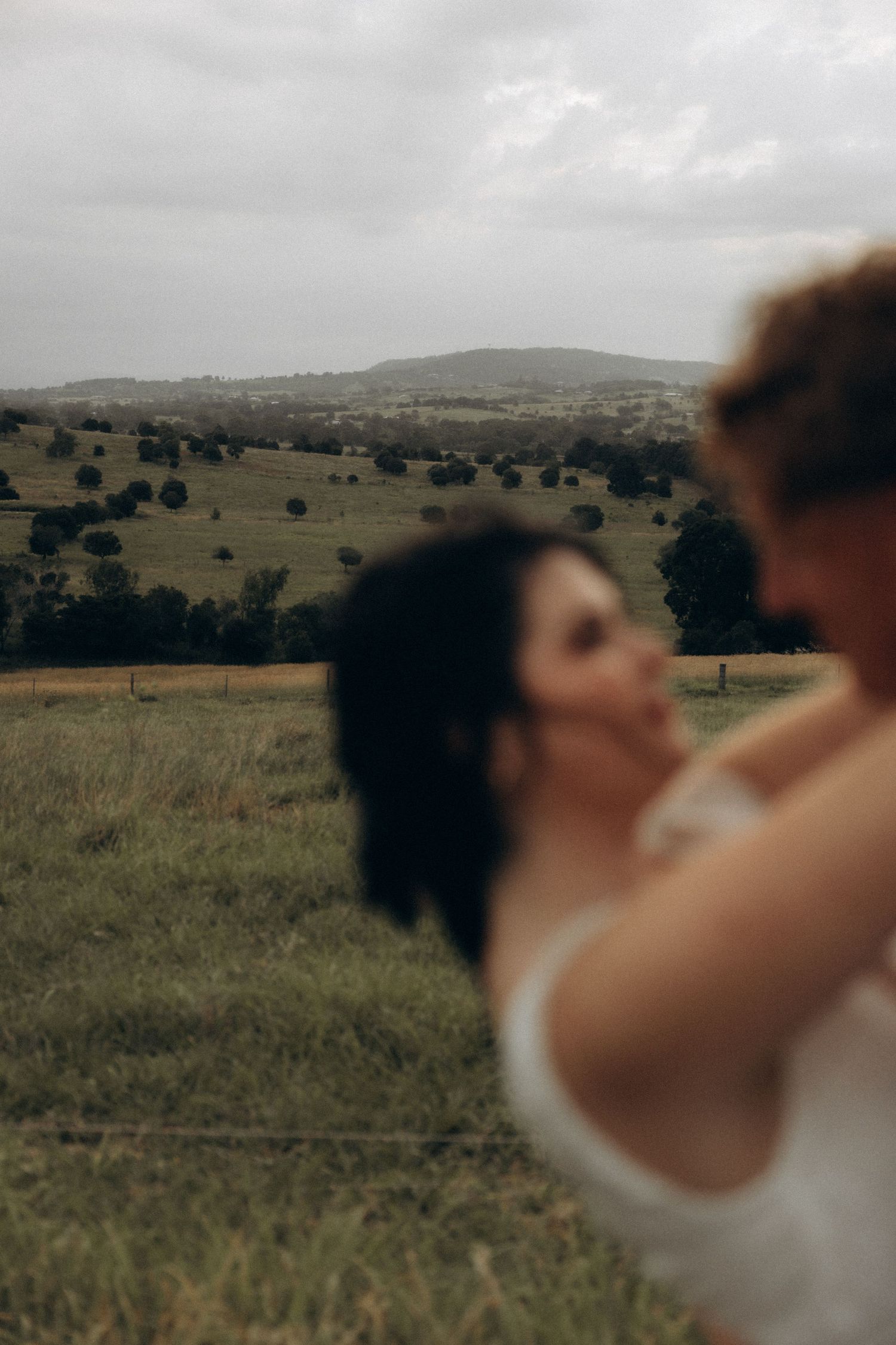 Romantic scene in a field with rolling hills and trees in the background.