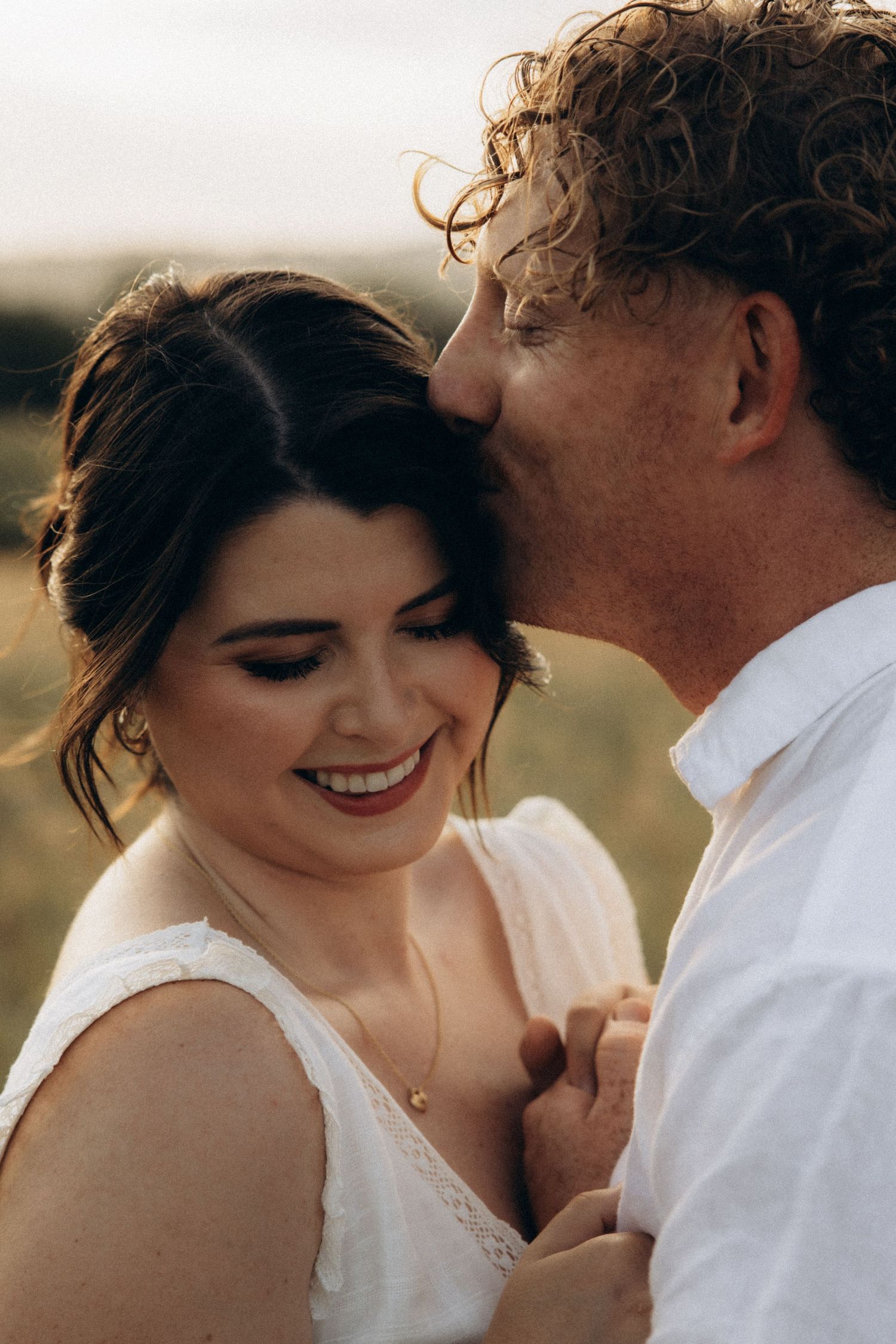 Candid romantic moment captured between couple in outdoor setting.