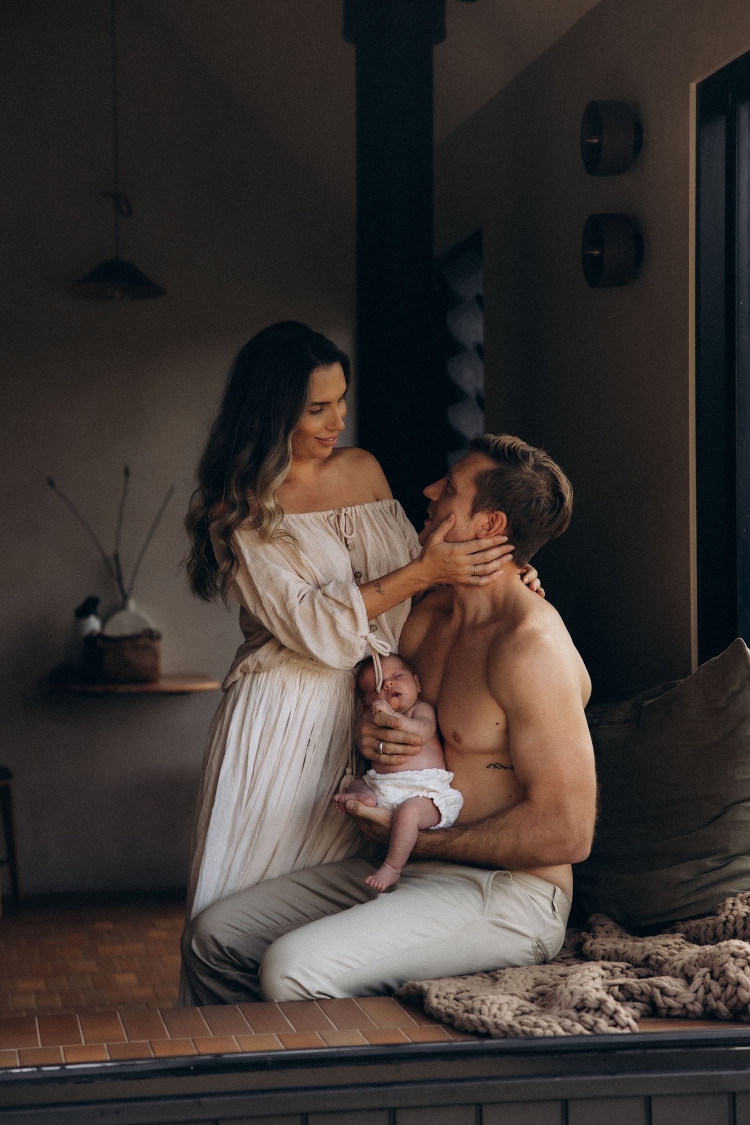 Intimate indoor scene with two people in white clothing sharing a tender moment.
