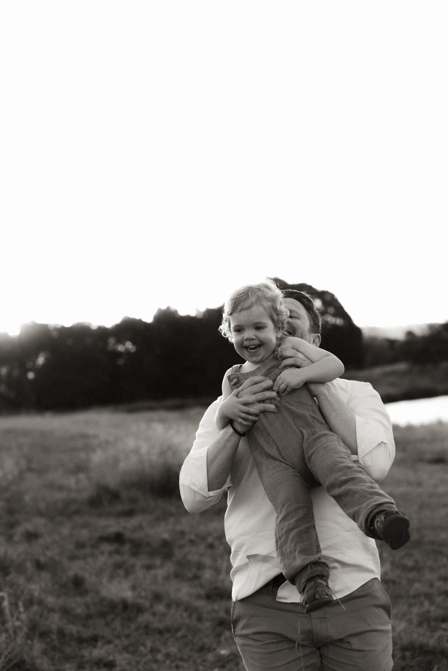 Candid black and white photo showing joyful interaction on a hillside.