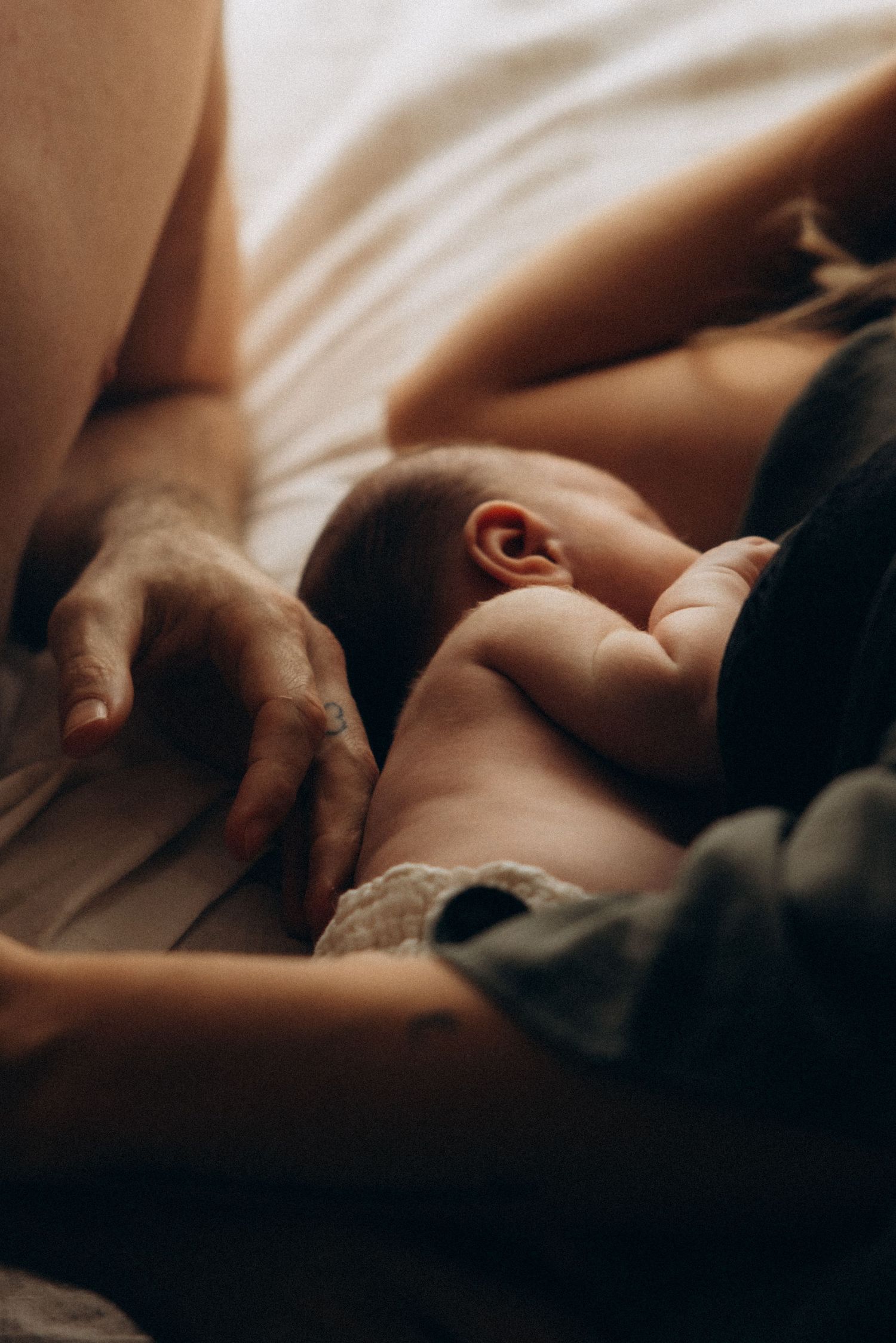 Artistic close-up photograph capturing gentle skin tones and soft shadows in warm lighting.