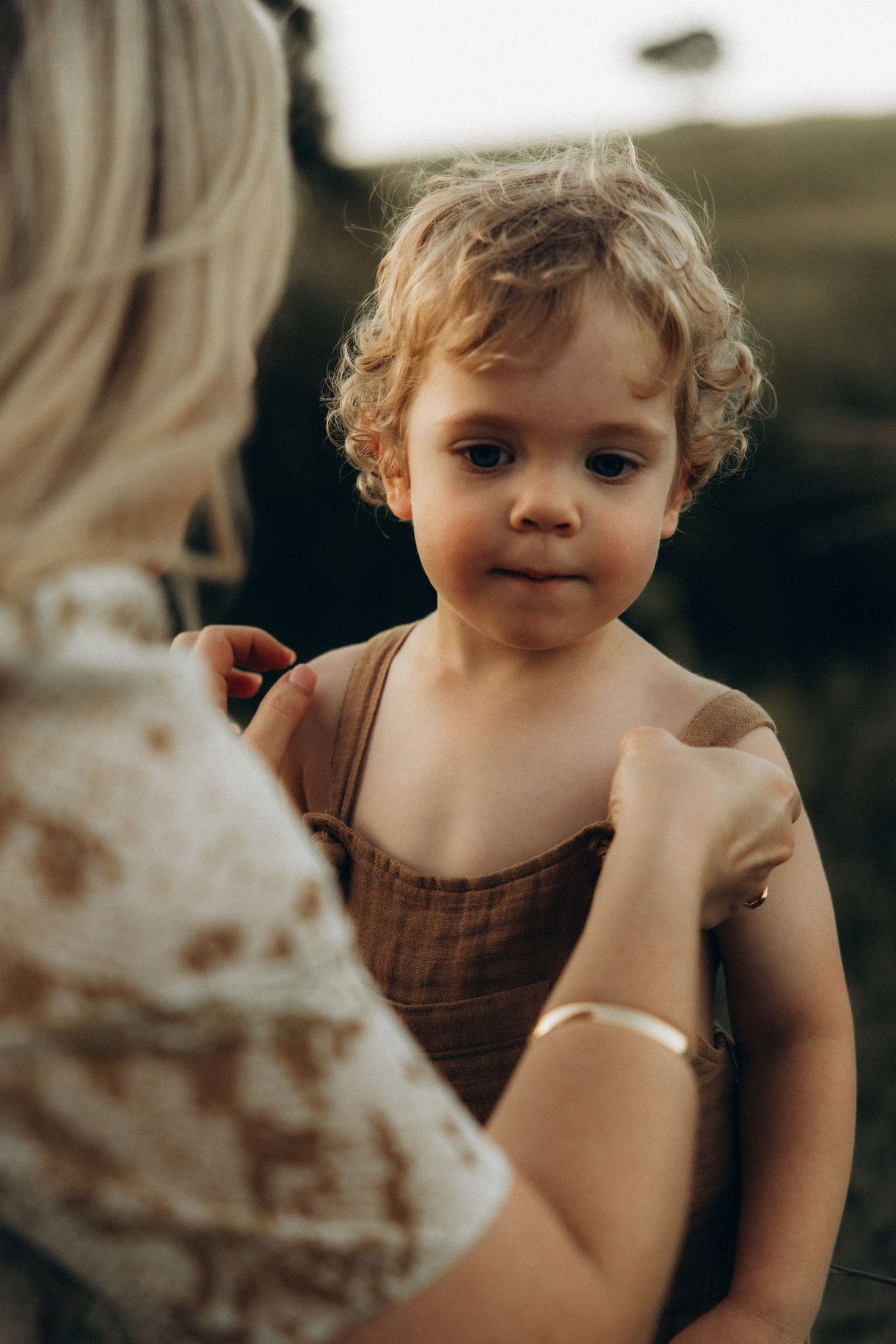 A close-up portrait in warm lighting captures a tender childhood moment.