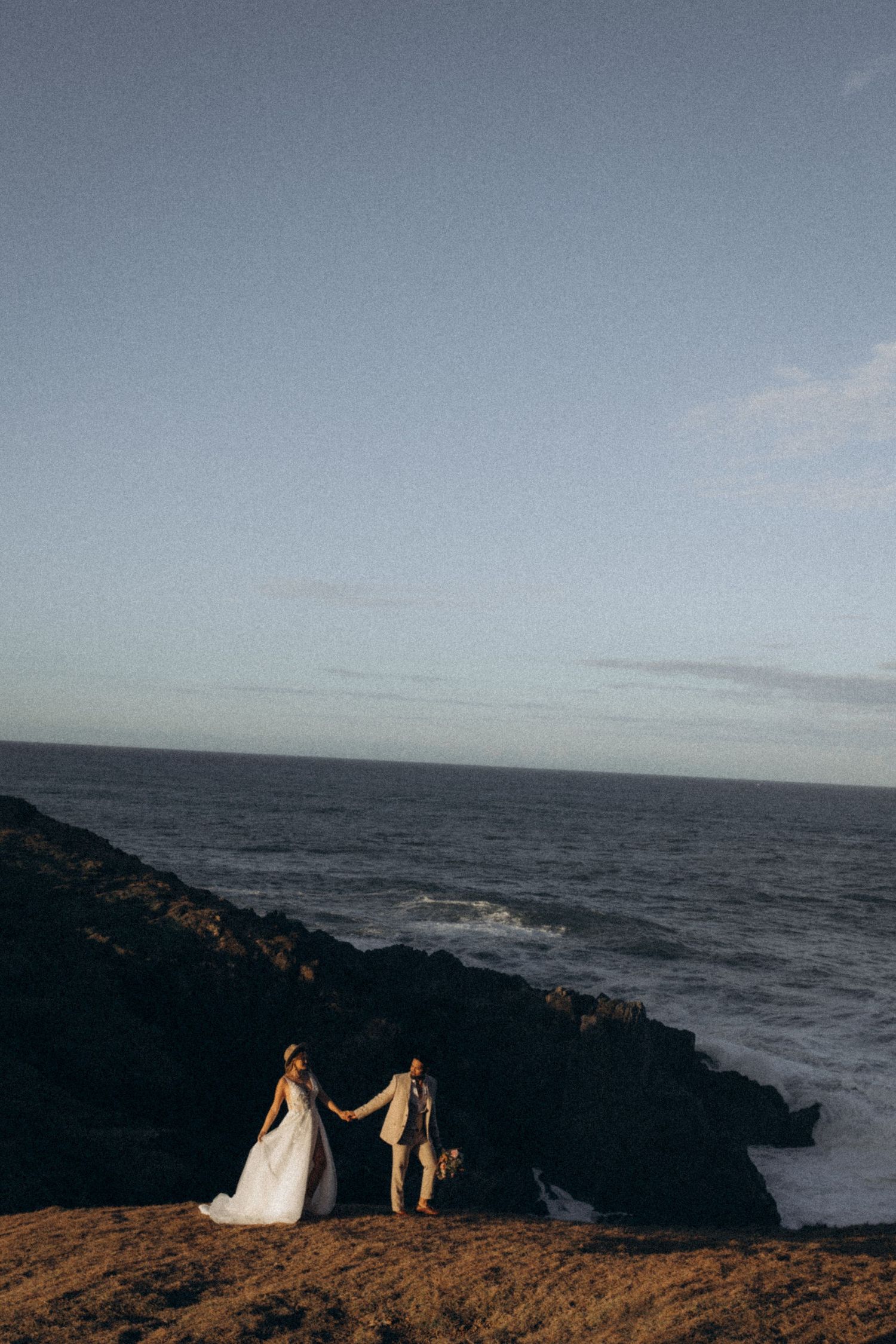 Coastal wedding photography with dramatic ocean cliffs and horizon views.
