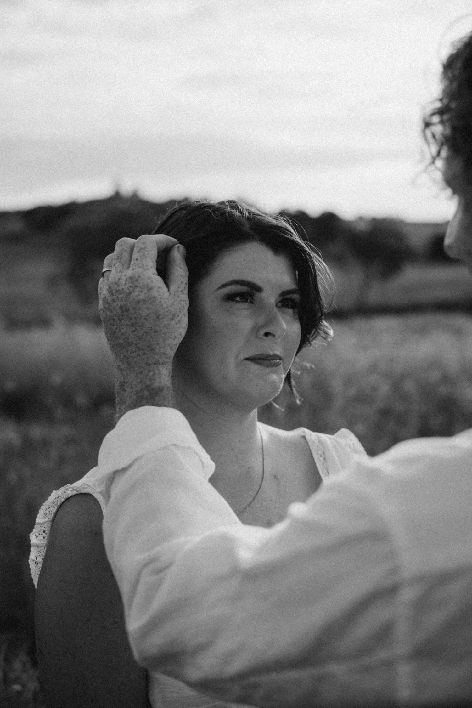 Black and white close-up of tender moment between couple in natural setting.