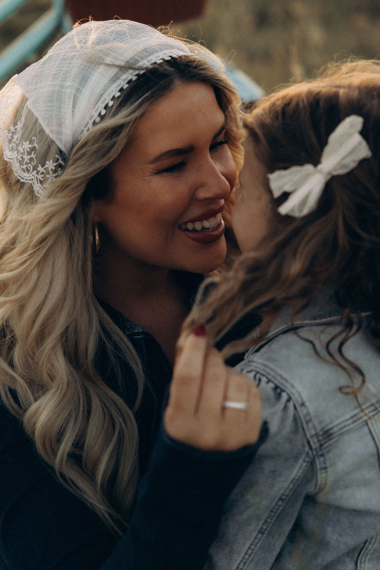 Two people share an intimate moment while wearing denim jackets at sunset.