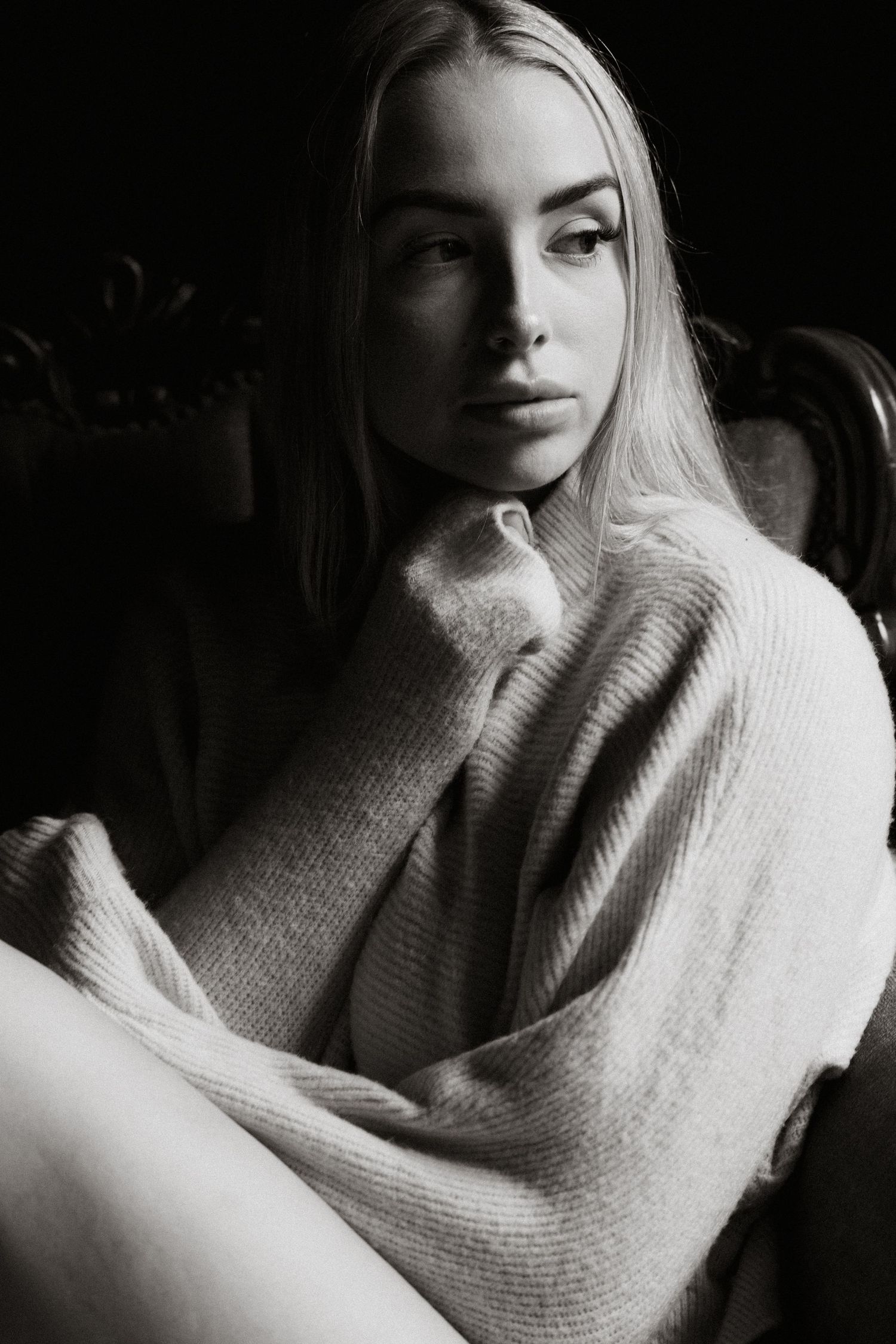 Close-up black and white portrait series with textured sweater and dramatic shadows.