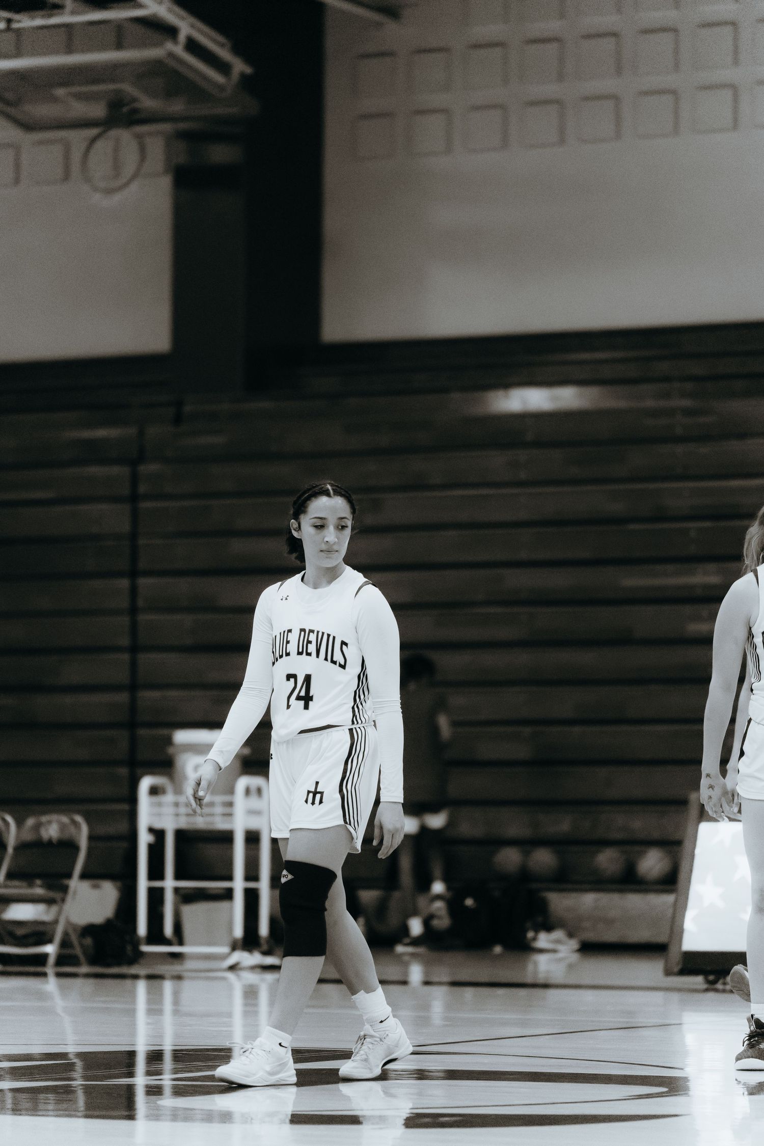 Basketball player in white jersey standing on court during game.