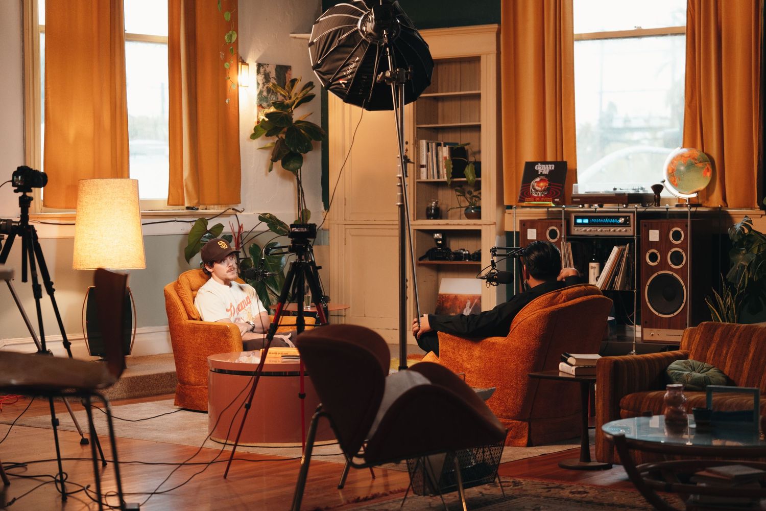 Cozy home studio setup with vintage furniture, cameras, and warm lighting.