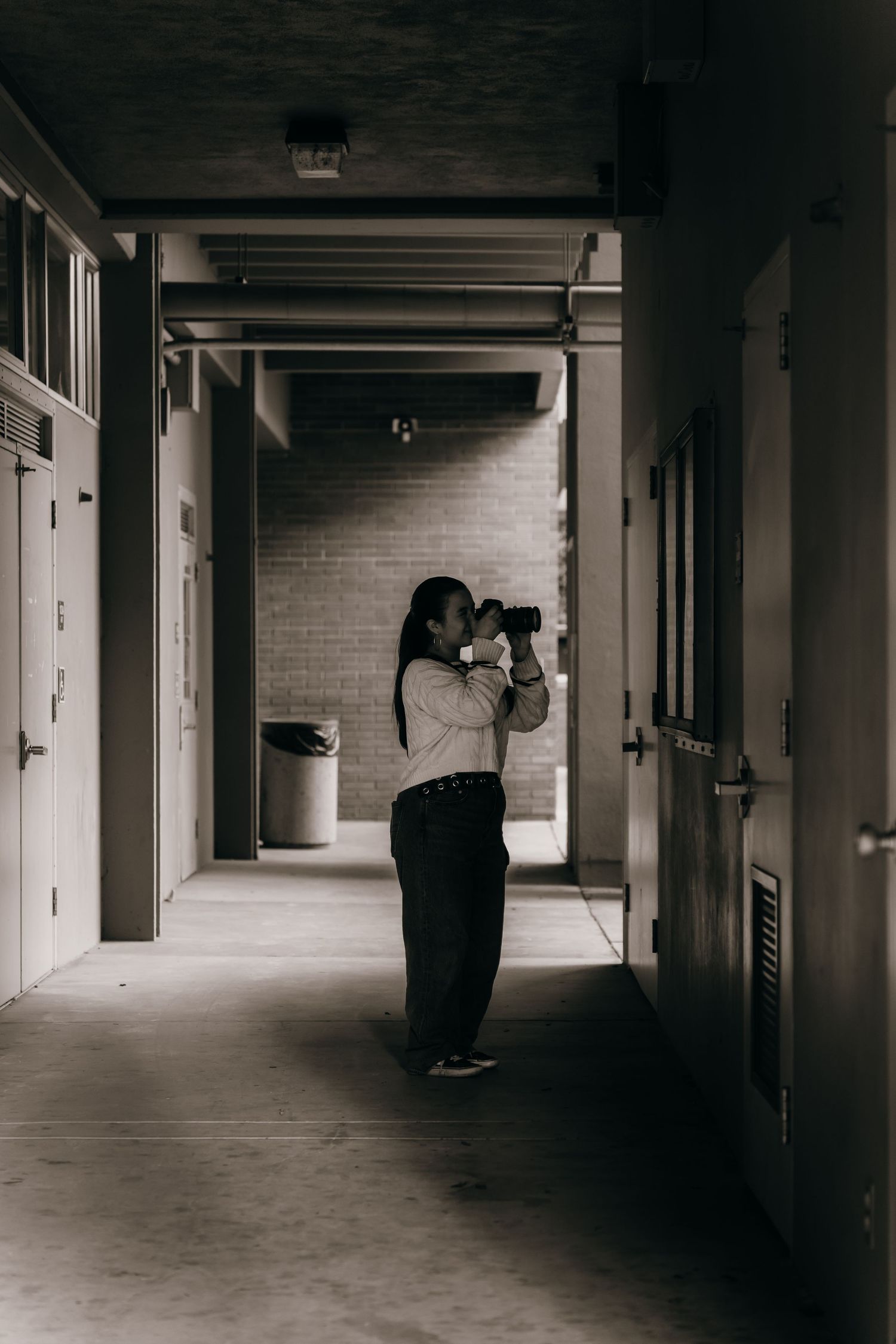 Photographer taking pictures in a dimly lit hallway.