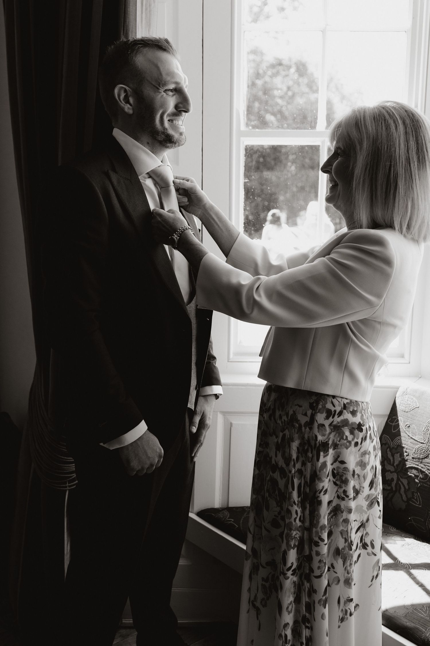 Black and white sequence of a couple dancing together in front of a window.