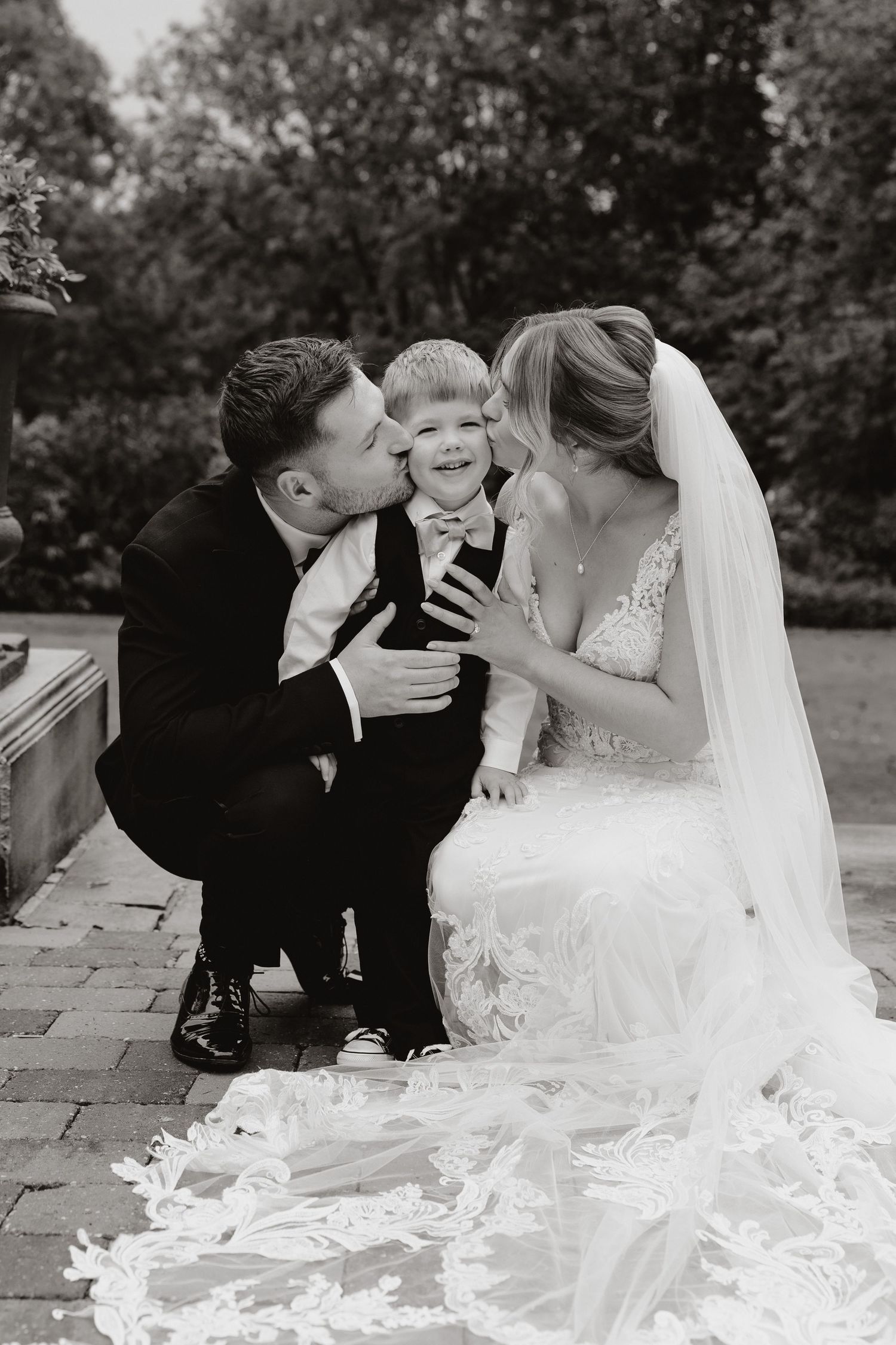 Black and white wedding photos showing tender moments between loved ones on stone patio with flowing veil.