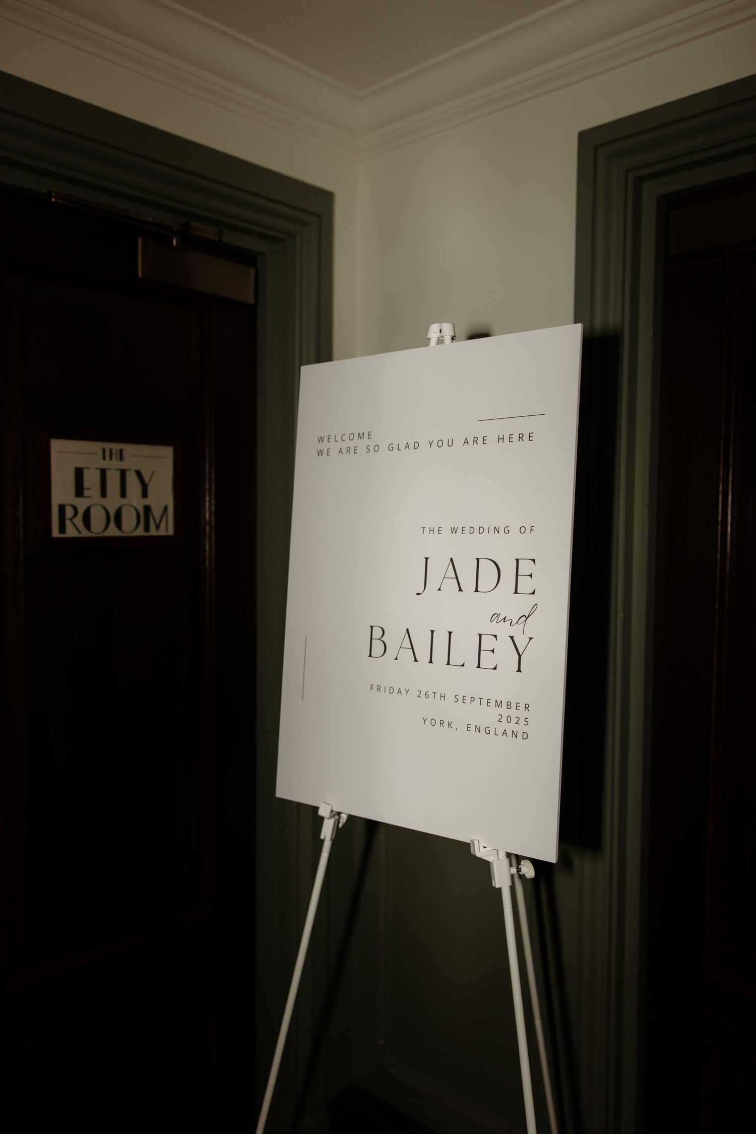 White text signs on stands display names like 'The Room', 'Jade', and 'Bailey' against a dark background.