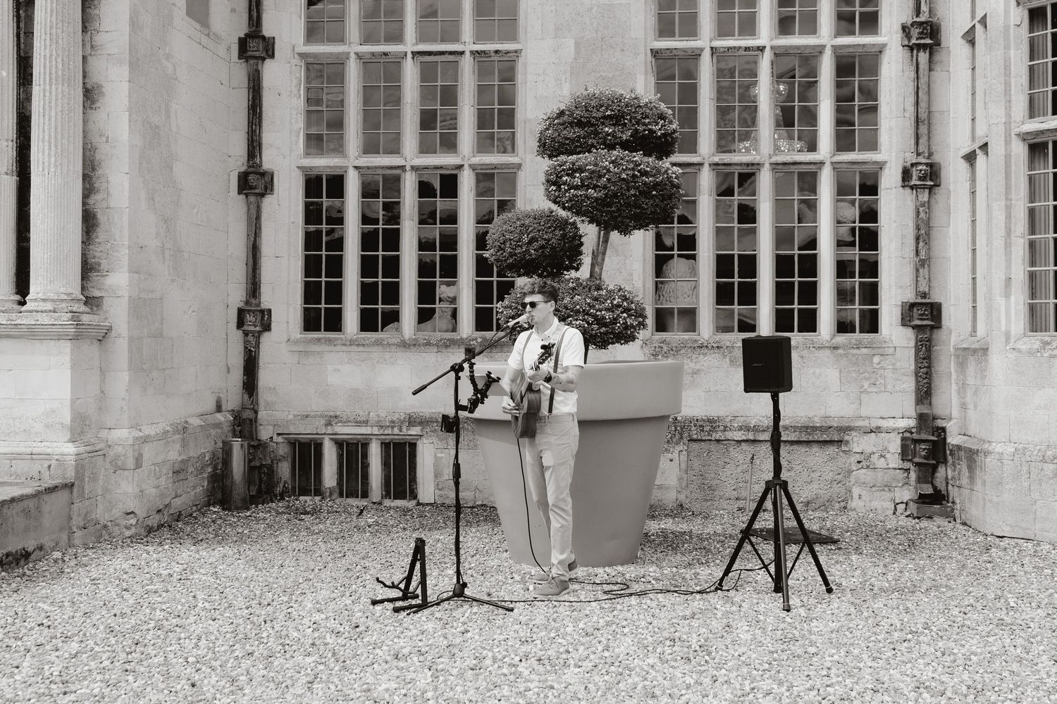 A series of black and white architecture photographs showing windows, pillars and stone courtyards of a historic building.