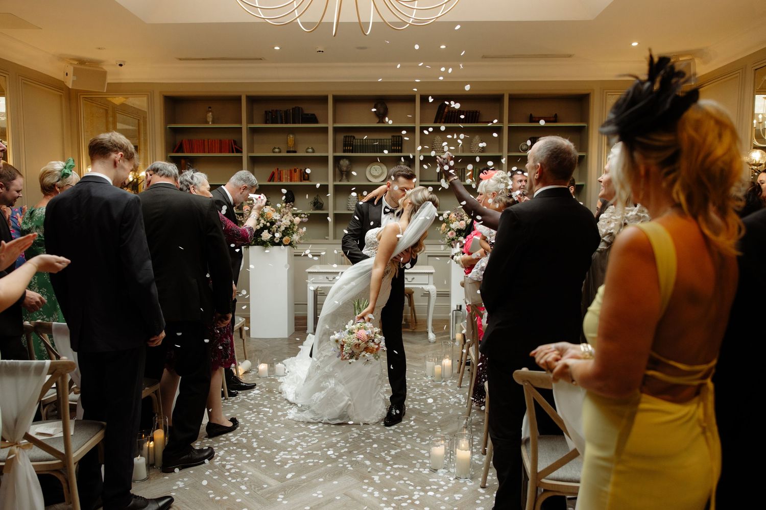 Guests celebrate at a wedding reception as bubbles float through the air during a festive party moment.
