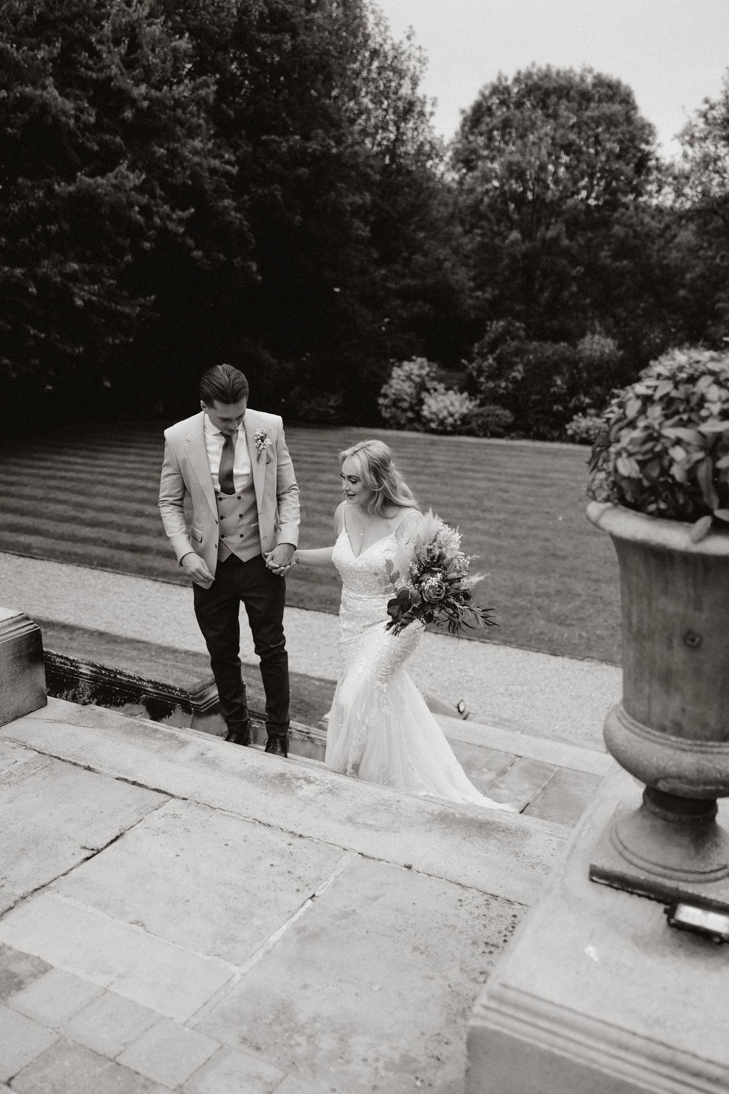 Black and white photo sequence showing bride and groom walking hand in hand down outdoor stone steps.
