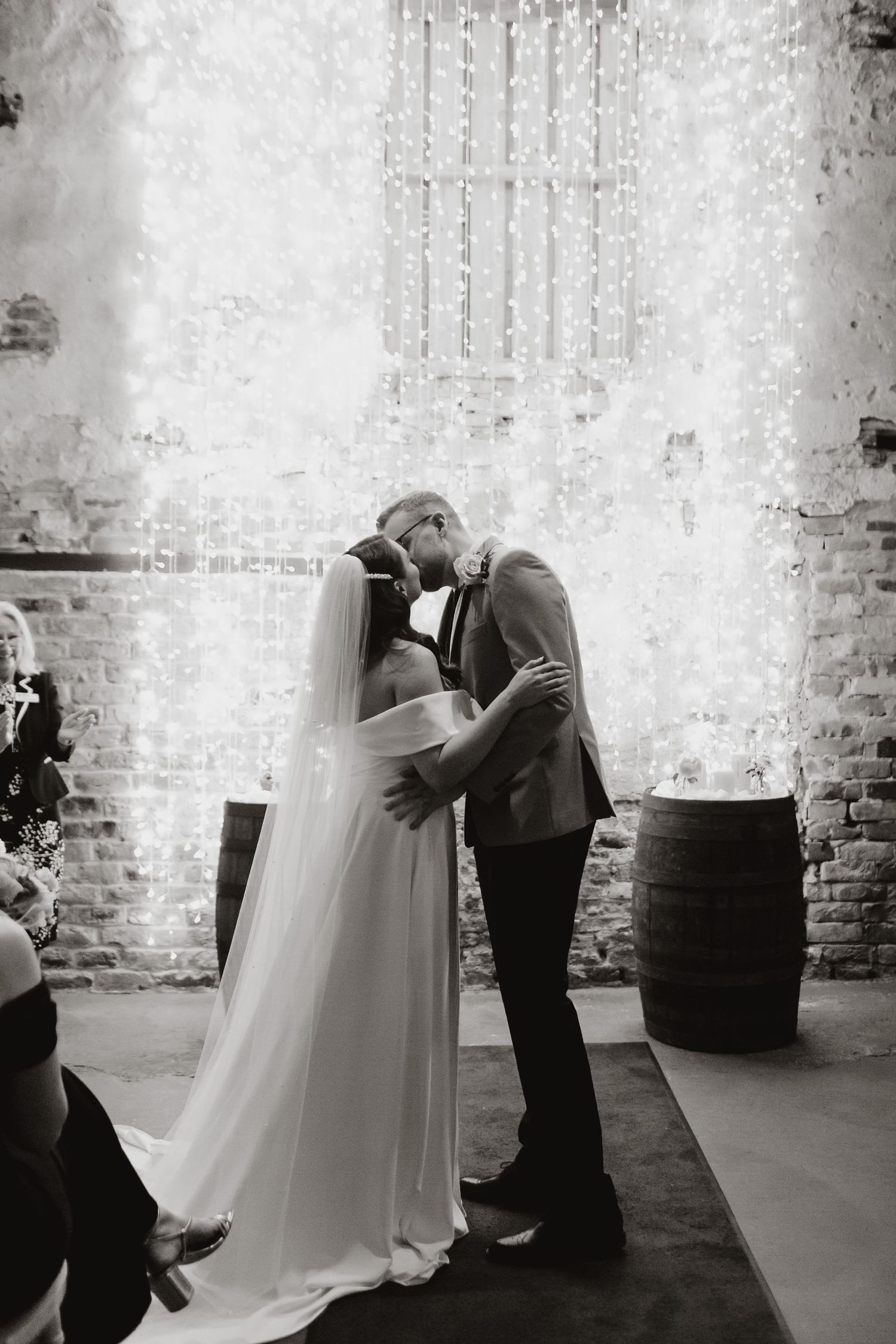 Black and white wedding photo sequence showing couple embracing in an industrial brick venue.